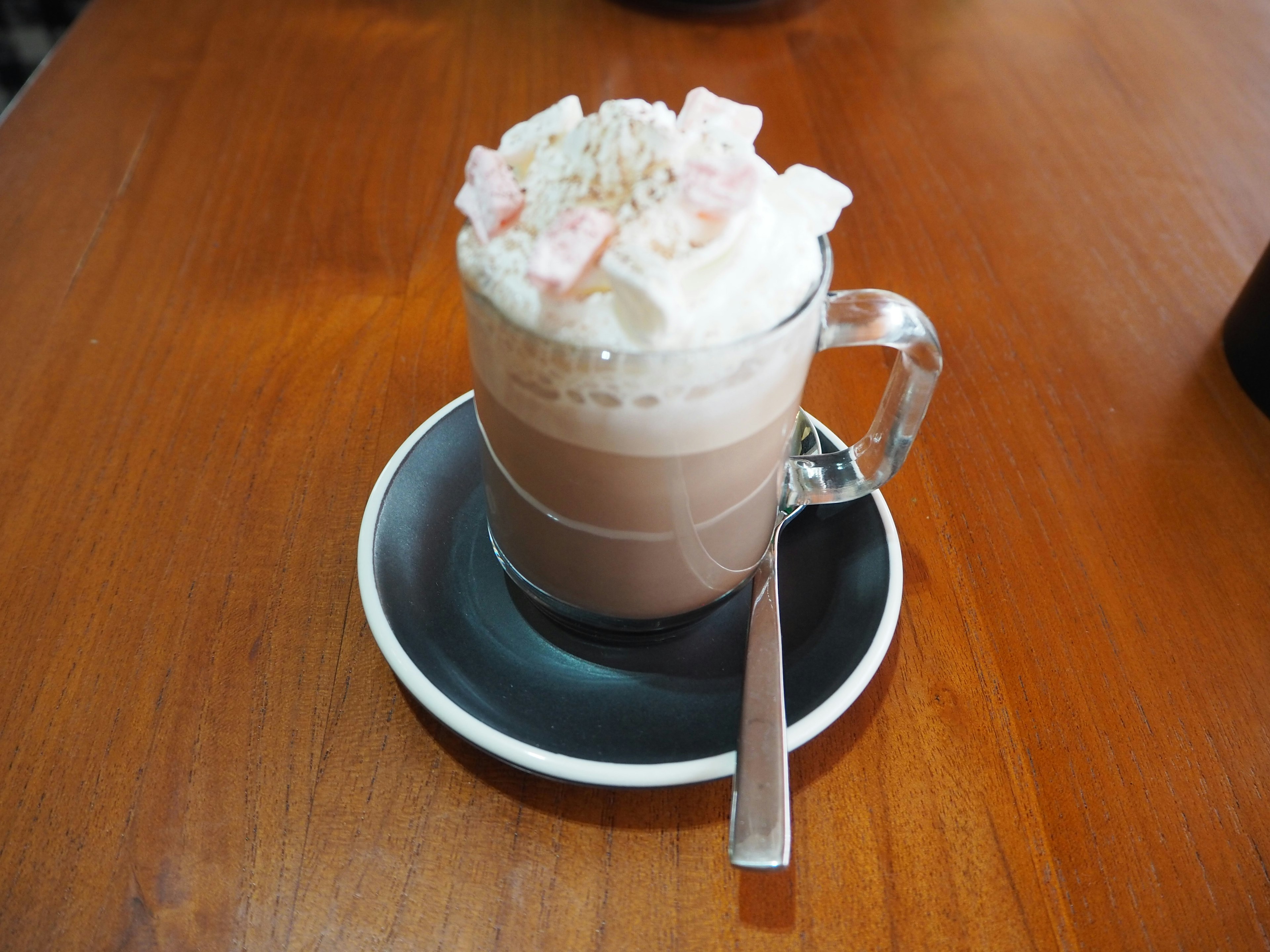 Bebida de chocolate caliente cubierta con crema y malvaviscos