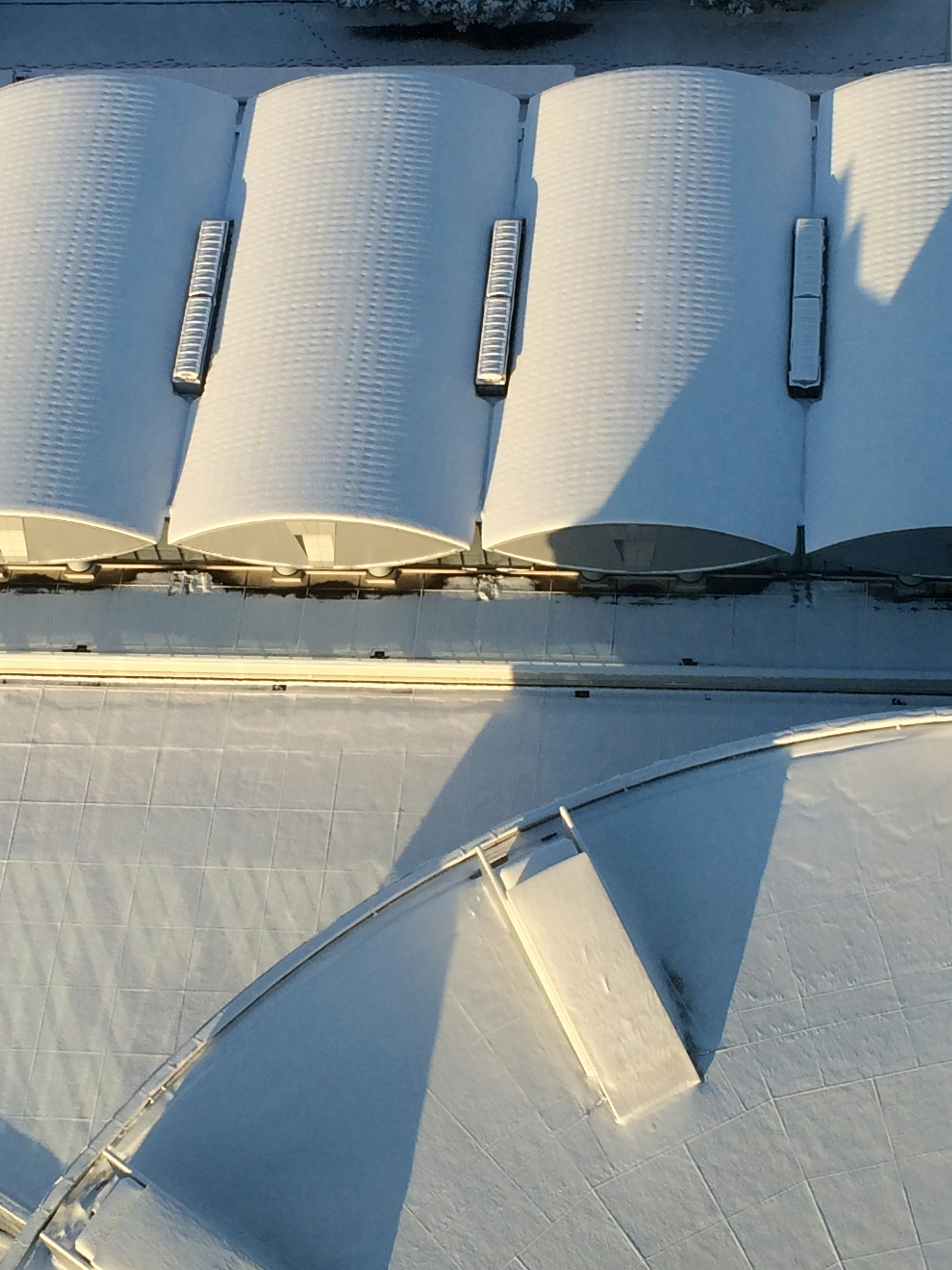 雪に覆われた屋根と影のある構造物の上空からの視点