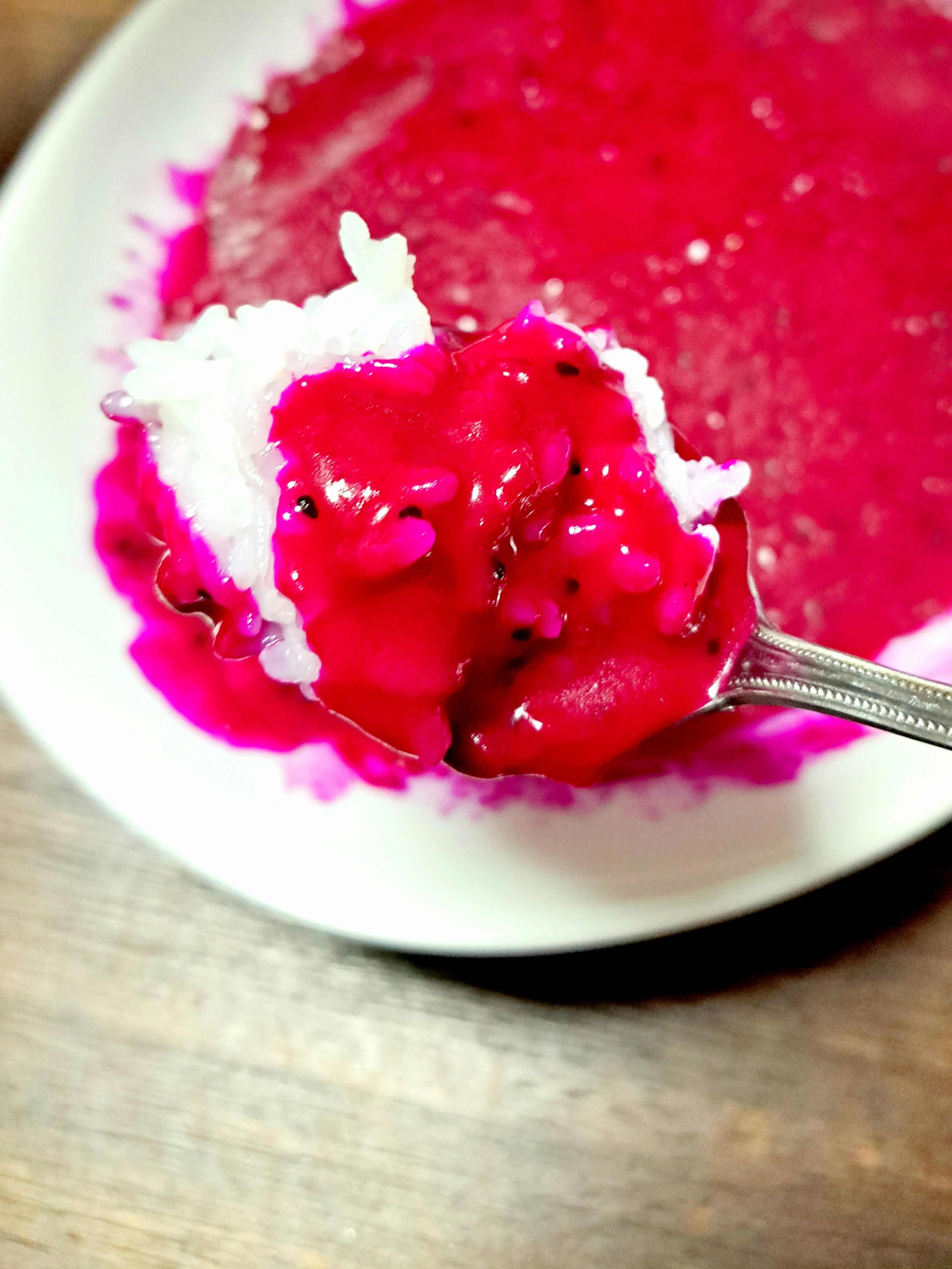 A spoonful of rice topped with vibrant pink sauce