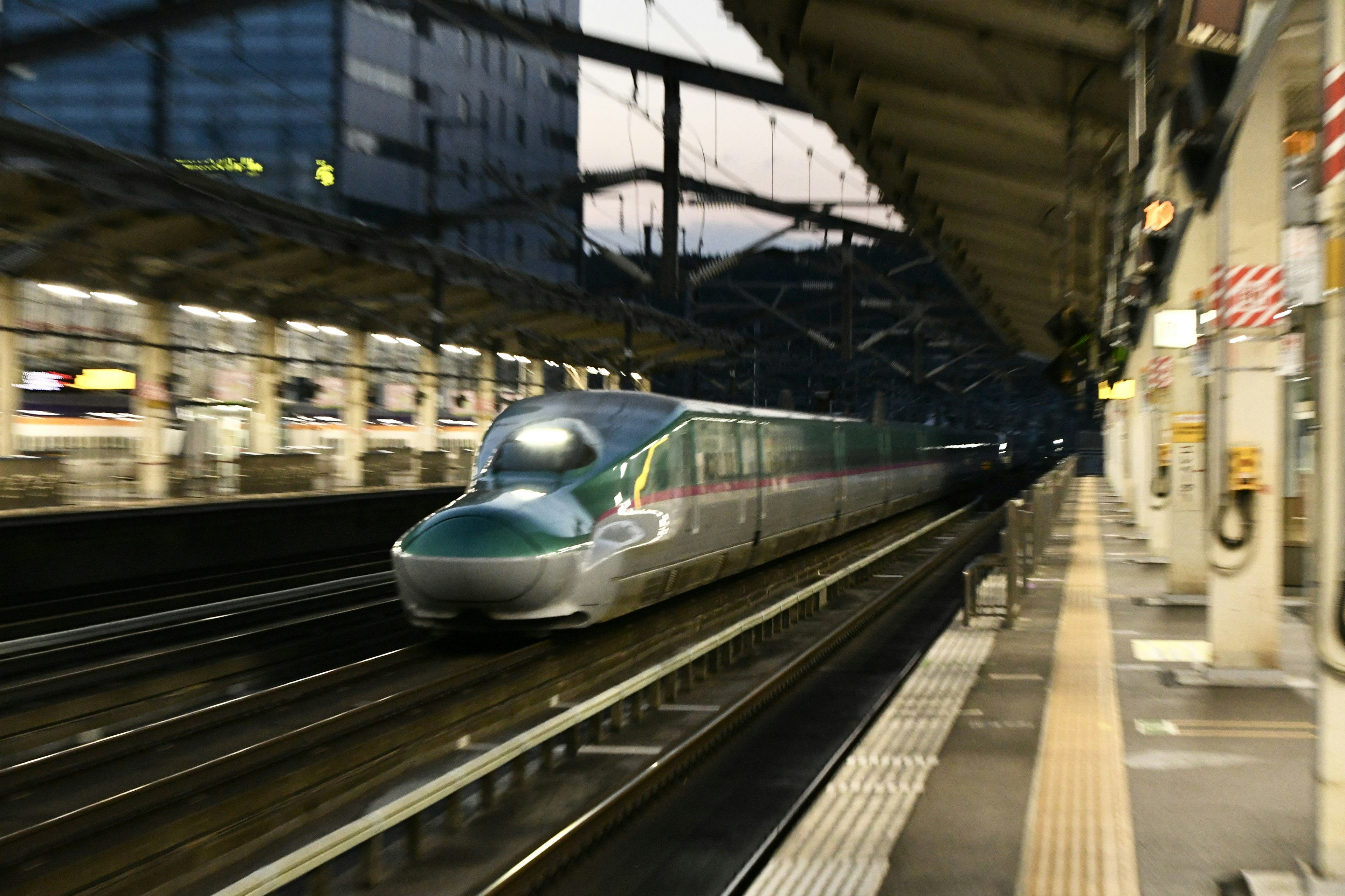 Shinkansen che passa attraverso una banchina della stazione