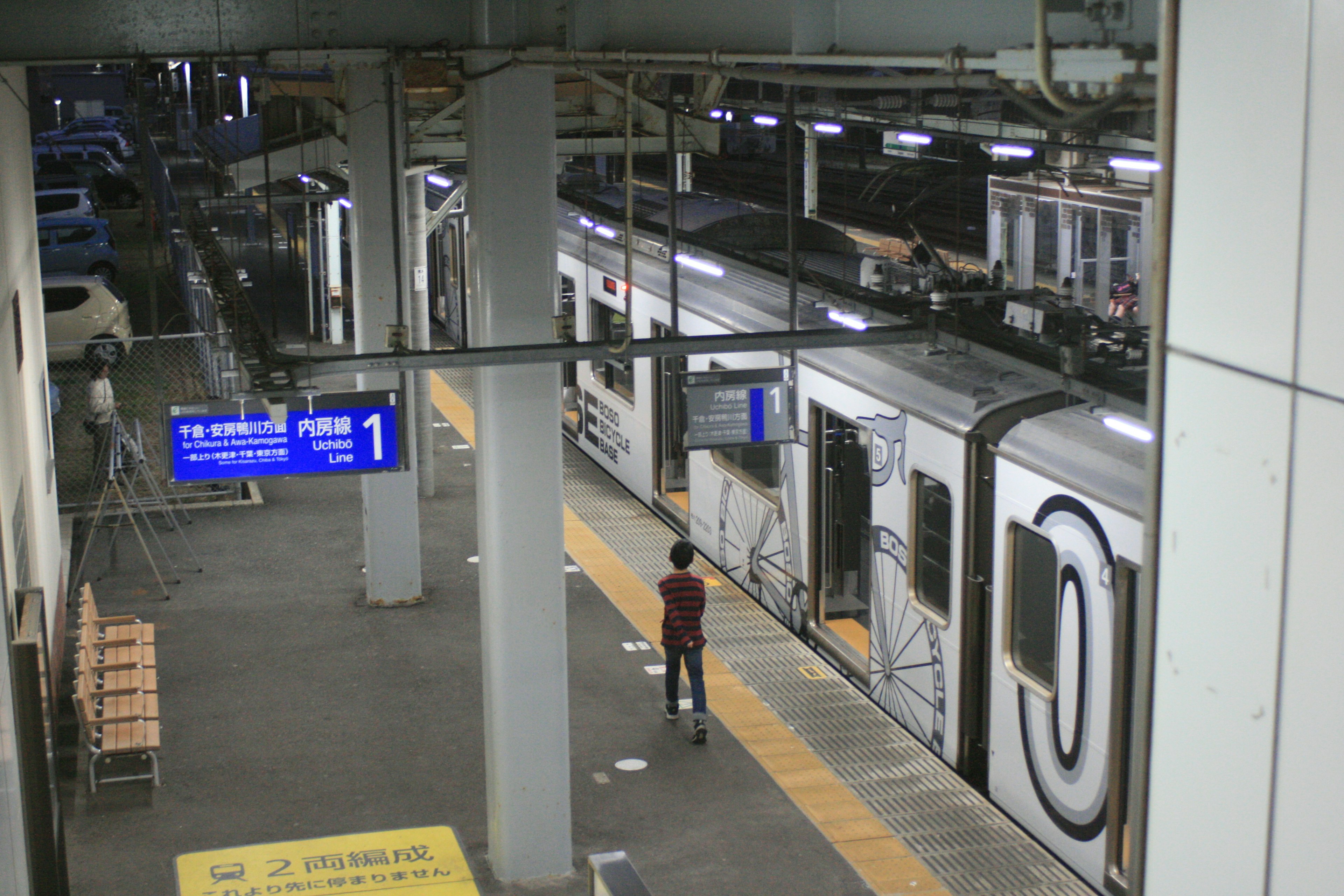 Una persona in piedi sul binario accanto a un treno in una stazione