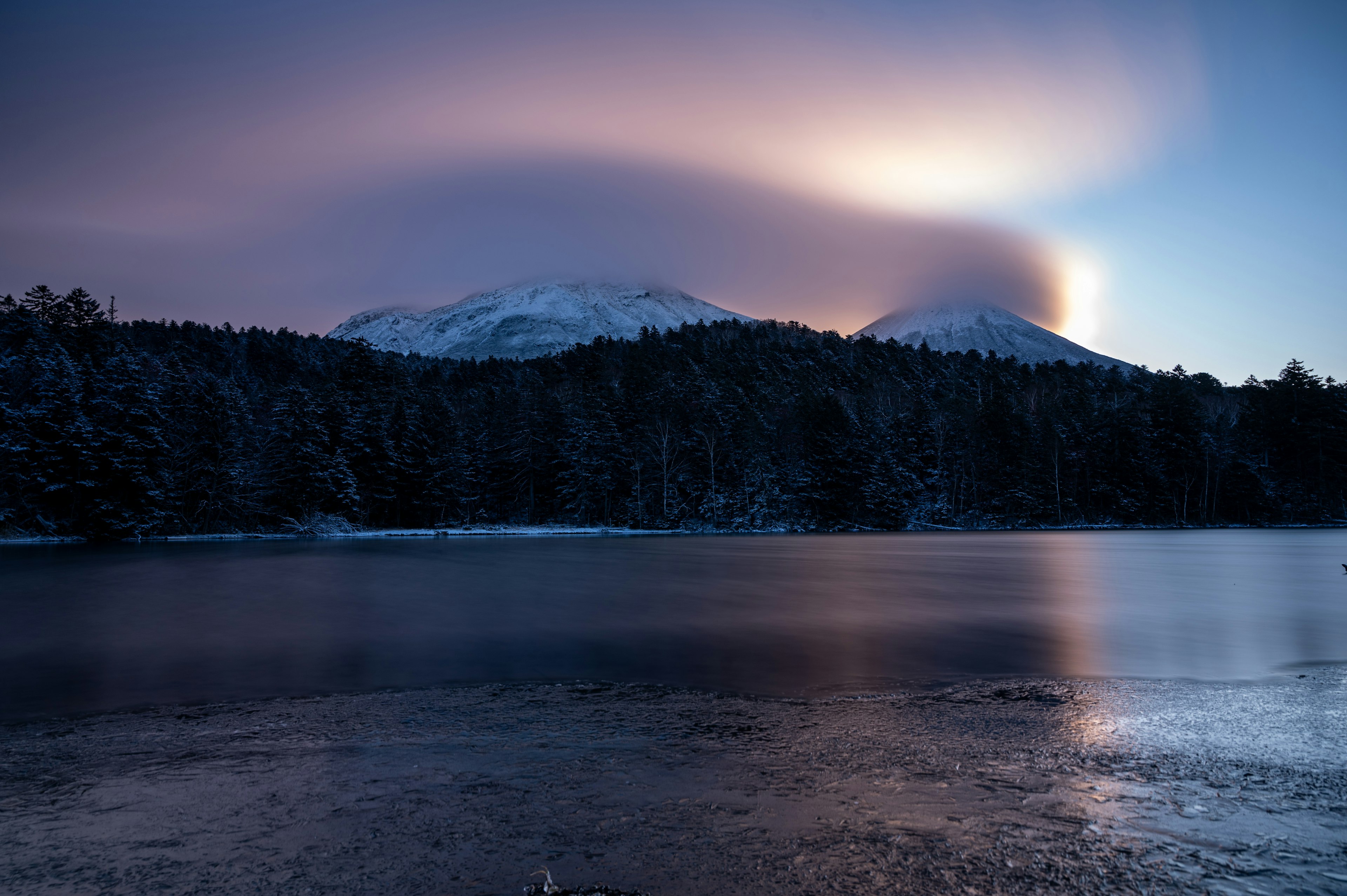 雪に覆われた山々と静かな湖の風景