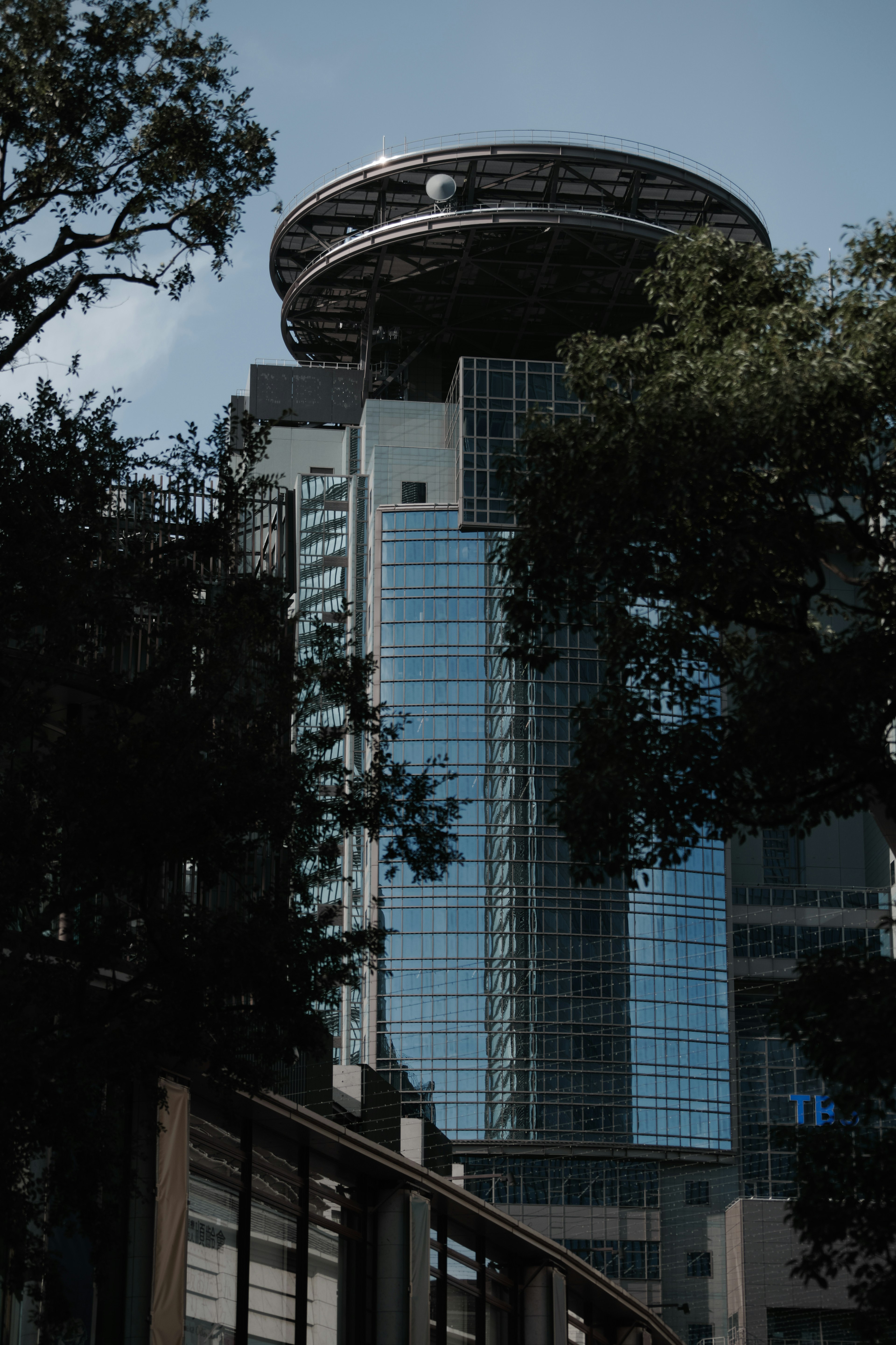 Paysage urbain avec un bâtiment moderne surmonté d'une structure circulaire