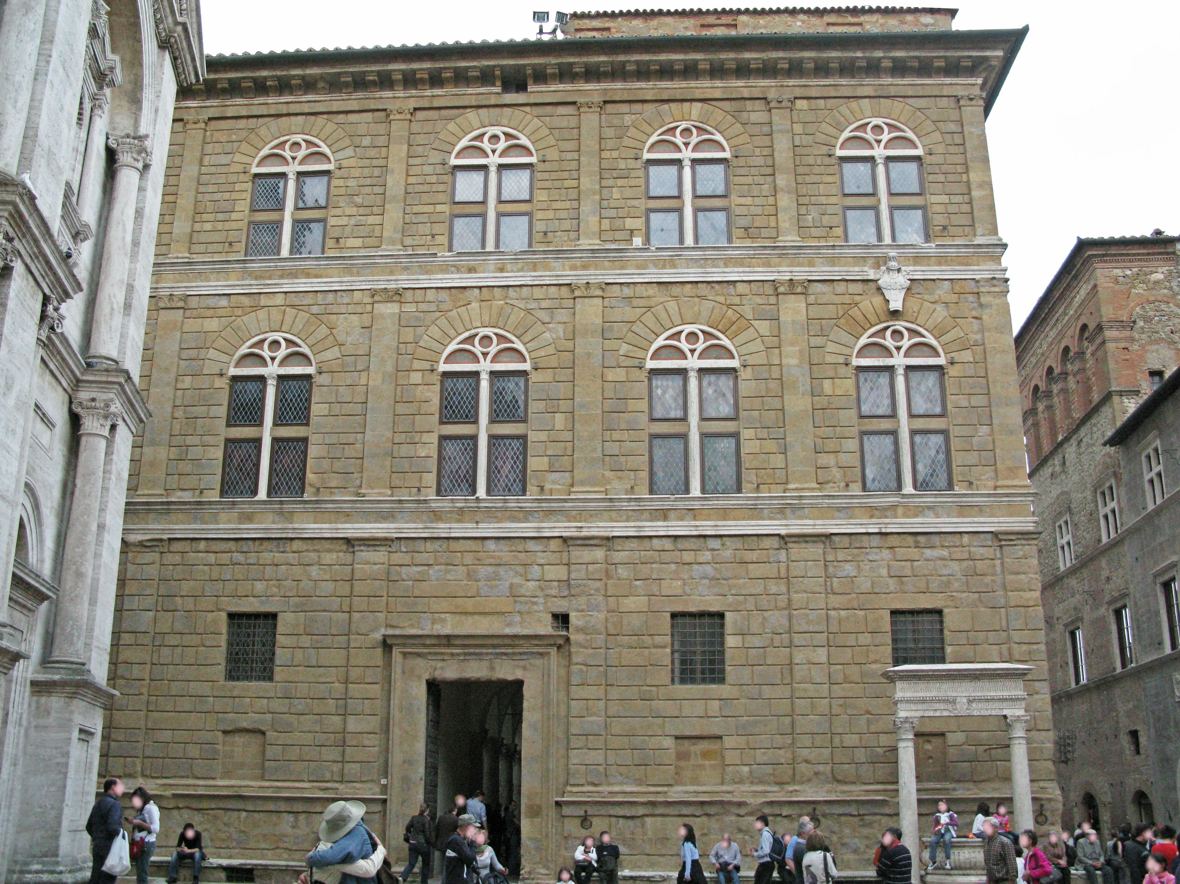 Historic building exterior in Florence featuring decorative windows and people