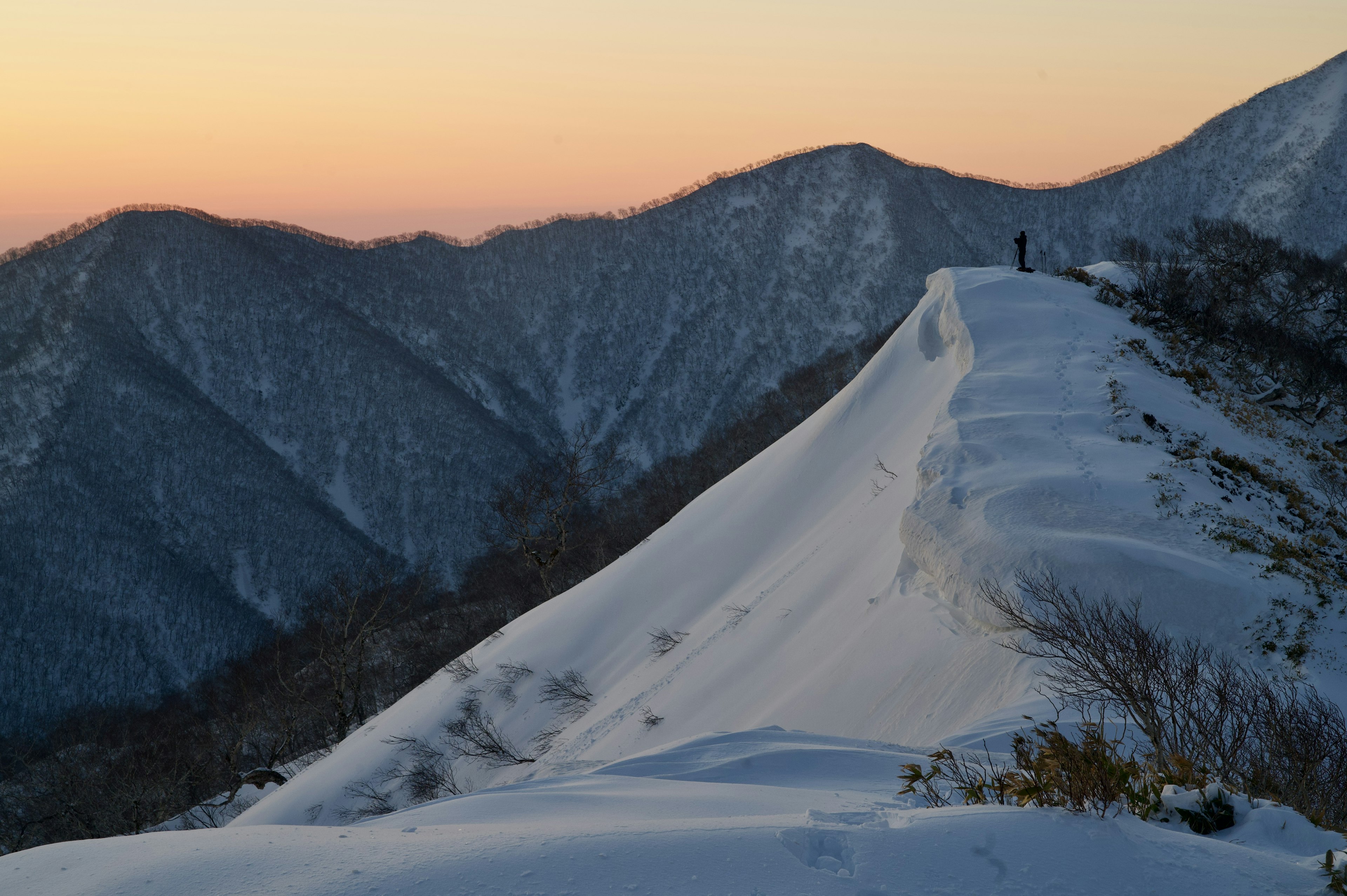 눈으로 덮인 산 능선과 일몰 하늘