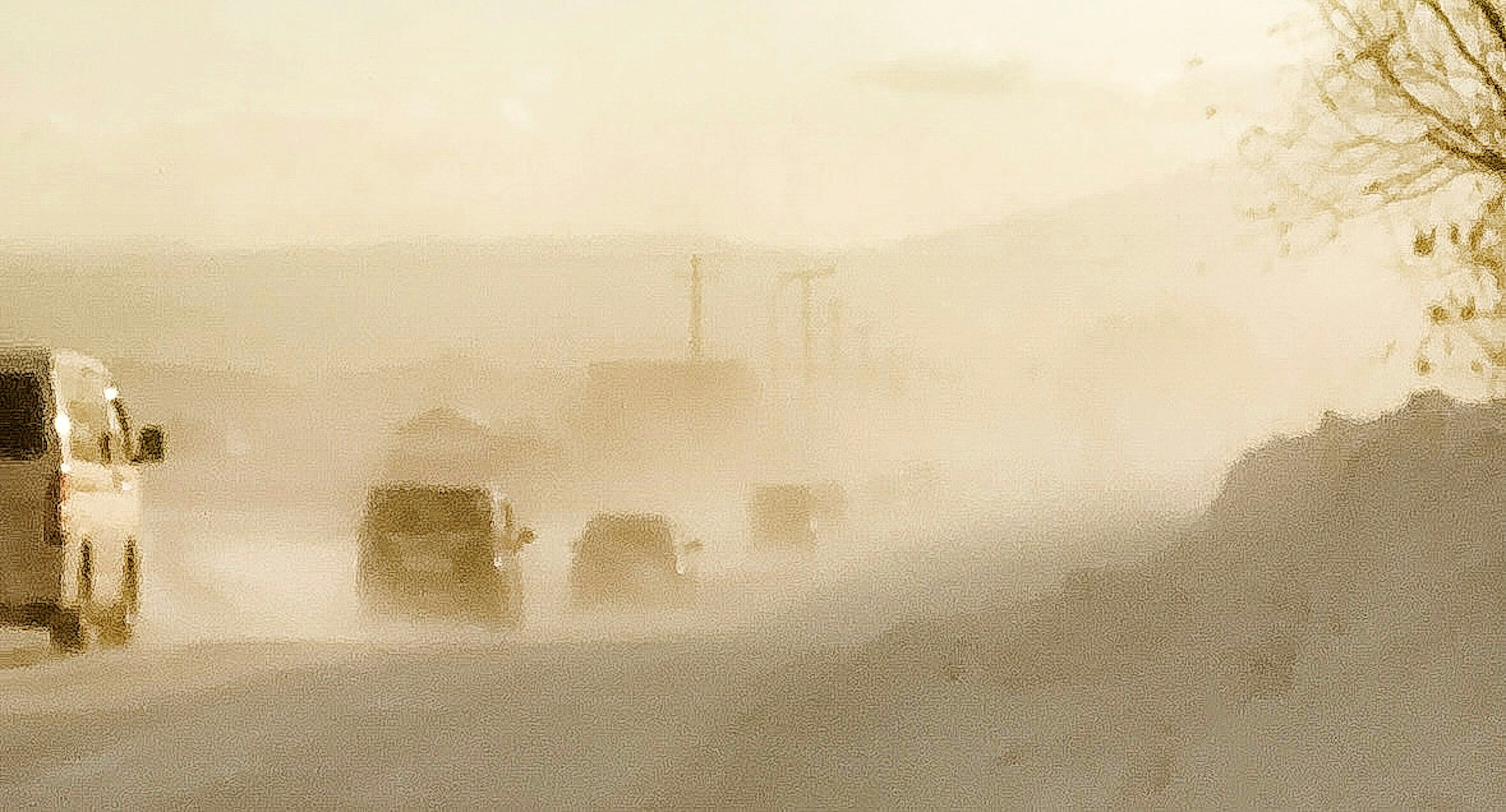 Vehículos conduciendo a través de una tormenta de polvo con un fondo brumoso en un paisaje invernal