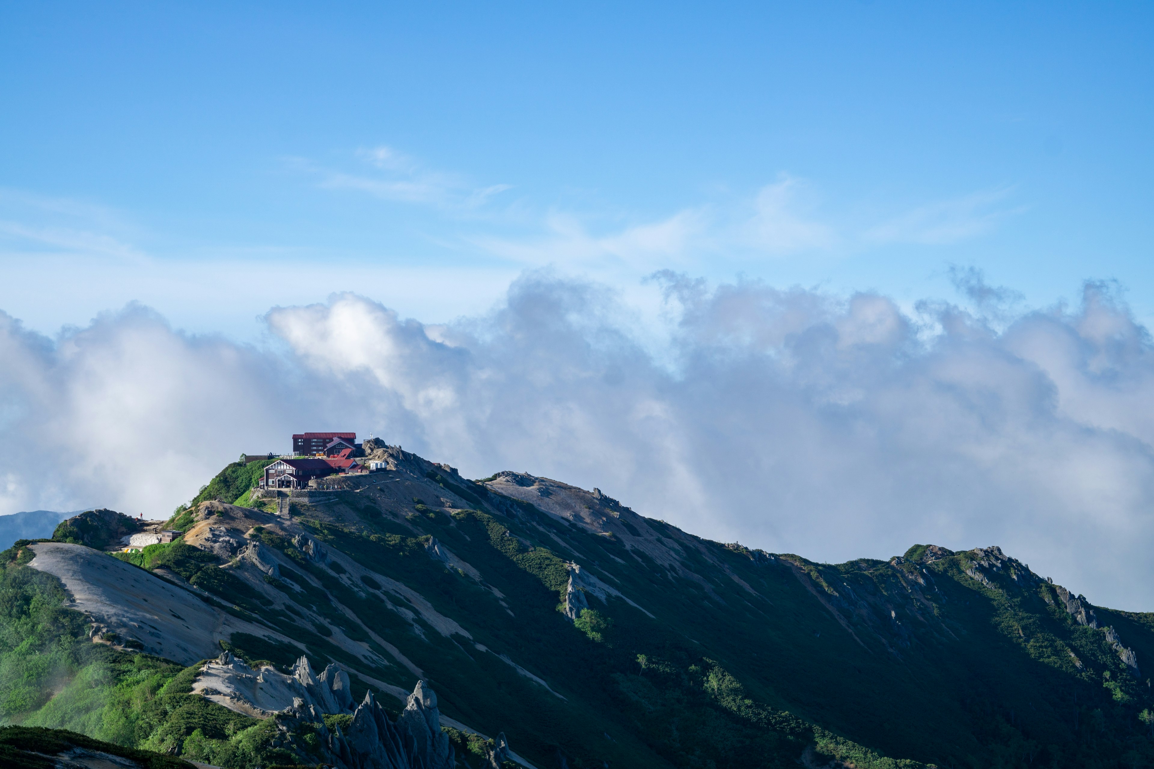 Bâtiment rouge situé au sommet de la montagne sous un ciel bleu