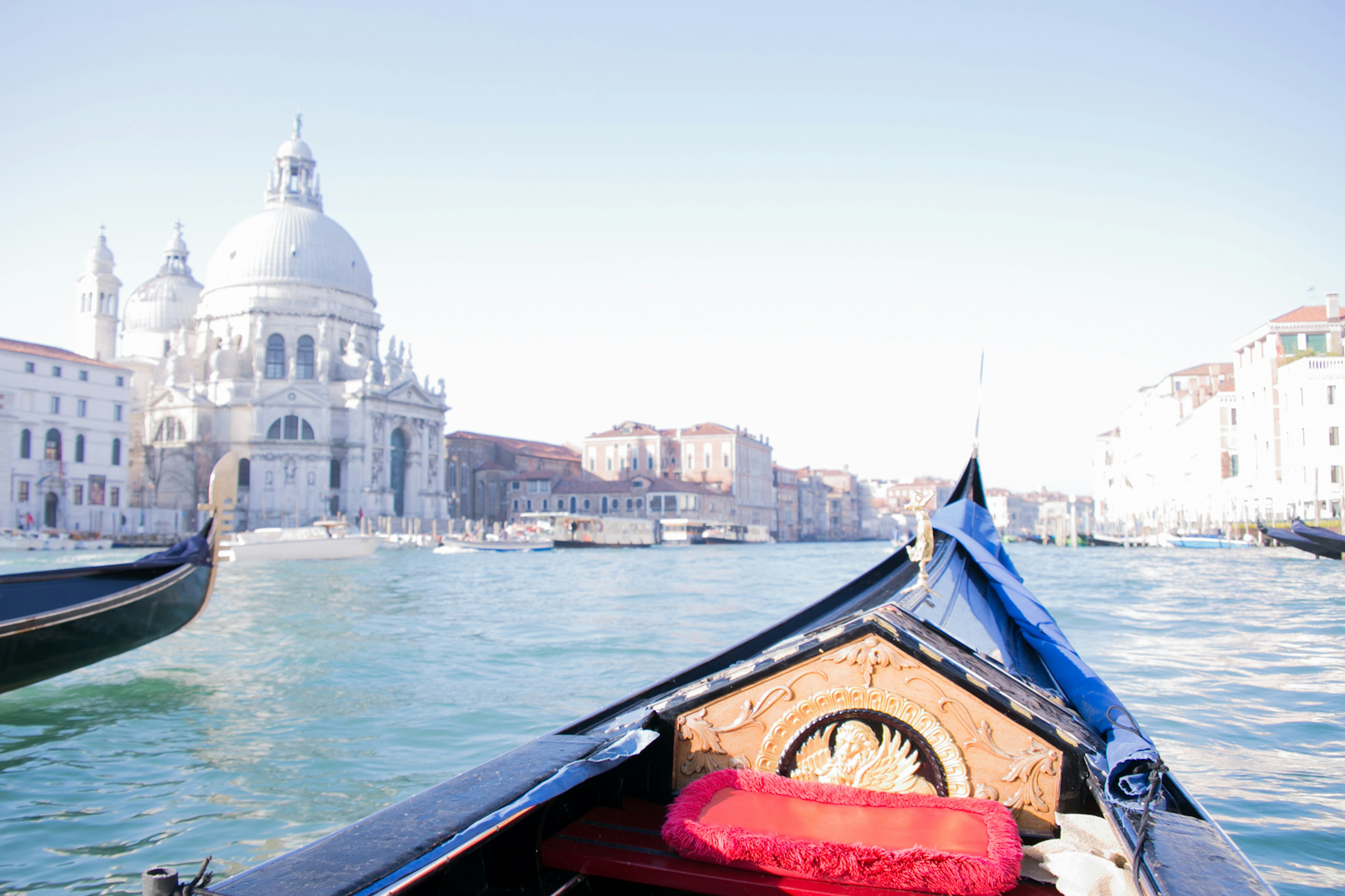 Primo piano di una gondola con vista sull'architettura bella di Venezia lungo il canale