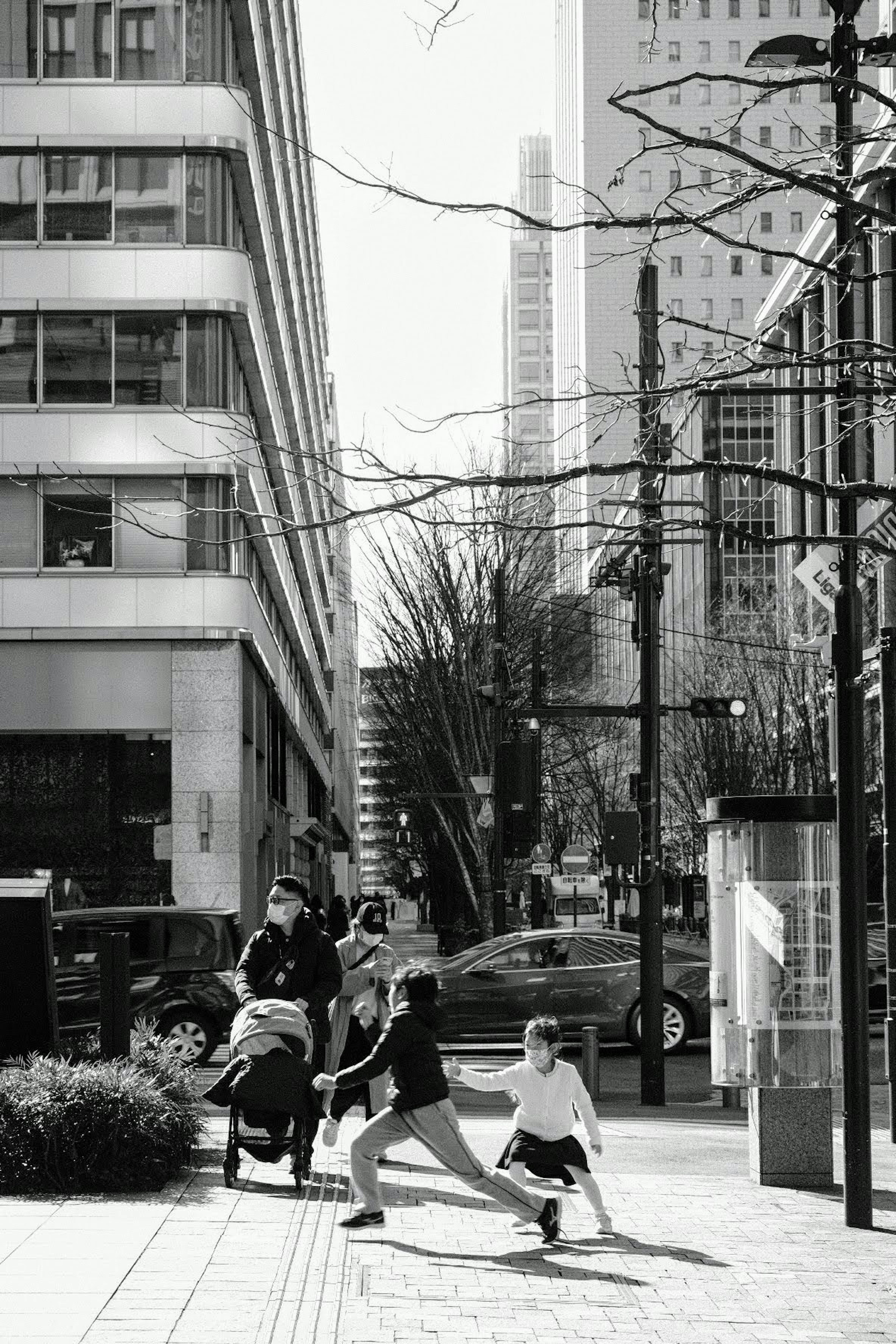 Escena urbana en blanco y negro con personas caminando Niños jugando en la calle