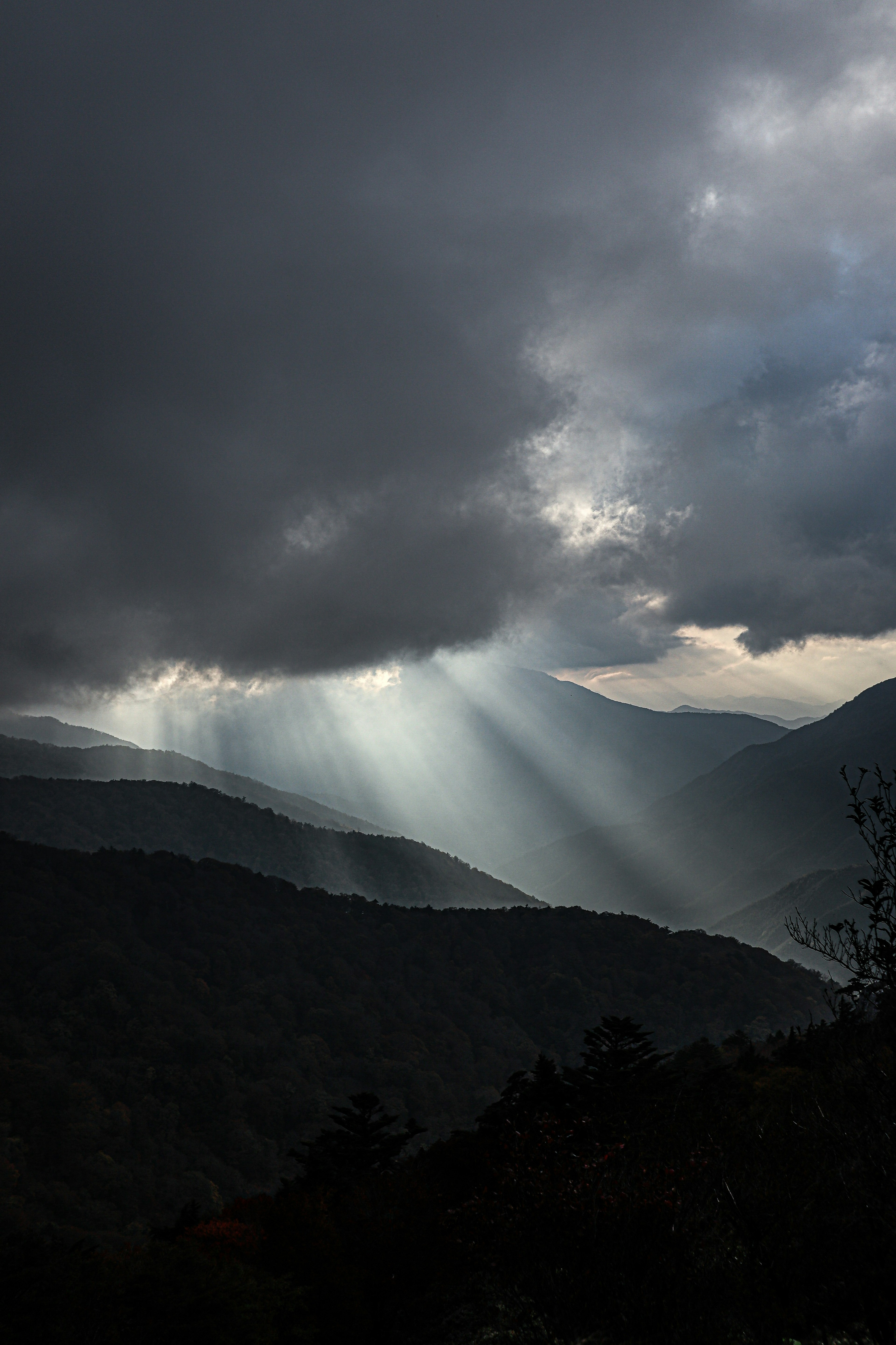 光線照耀在黑暗雲層下的山脈