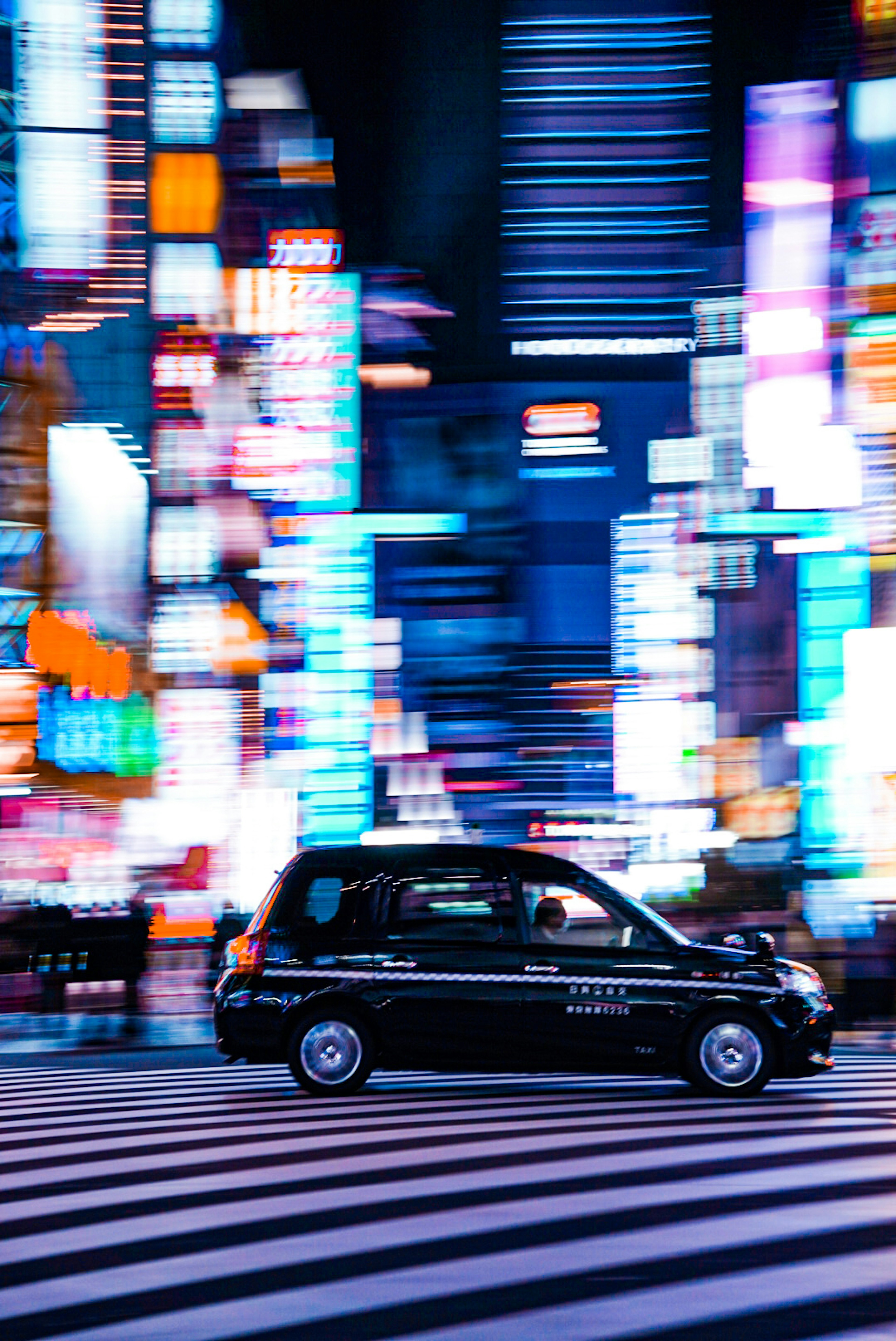 Black taxi driving through neon-lit streets of Tokyo at night