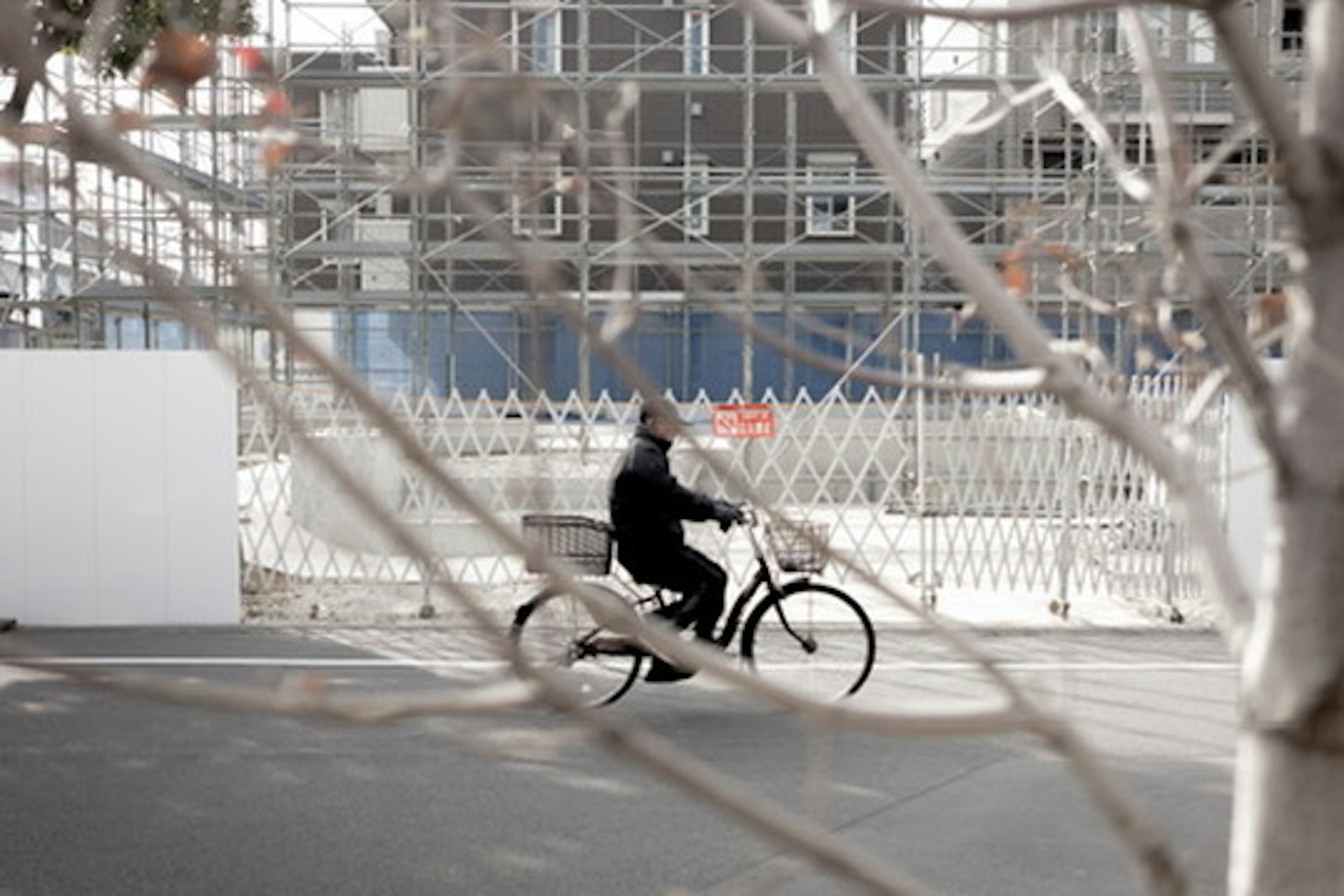 Person riding a bicycle with a construction site in the background