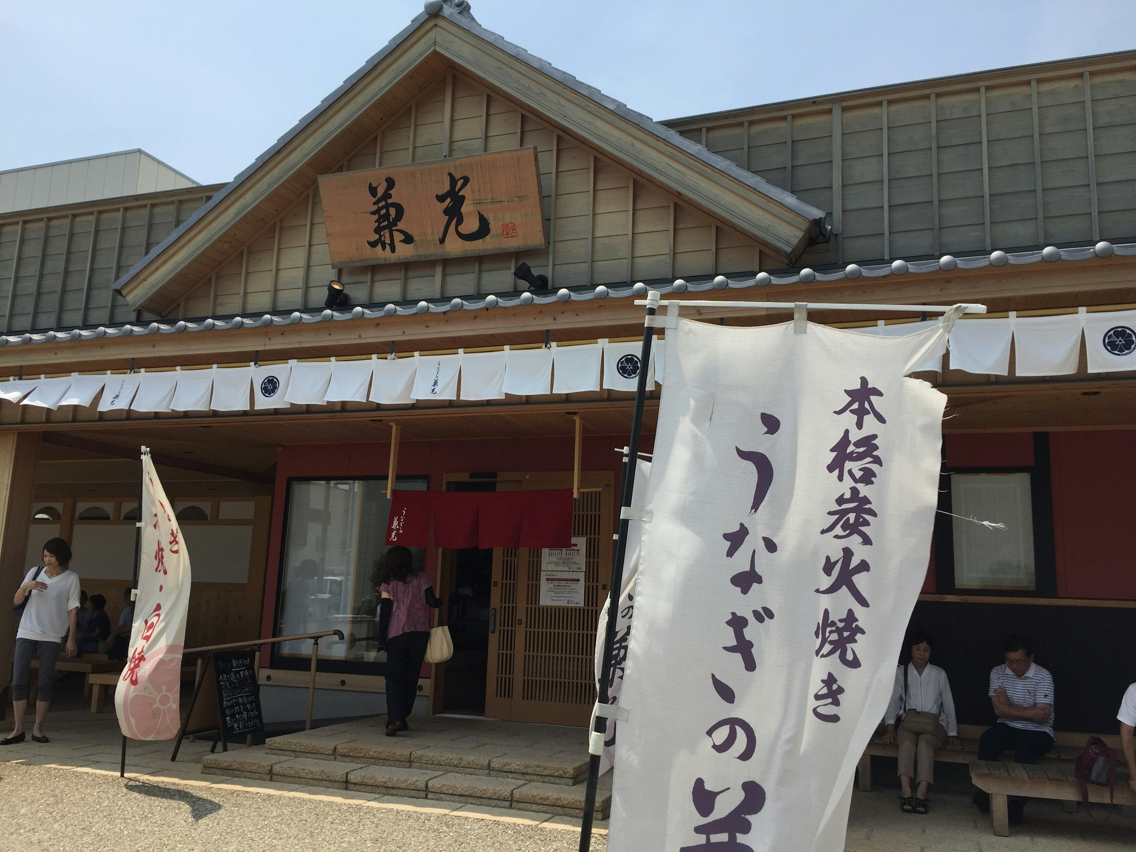 Traditionelle japanische Restaurantfassade mit dekorativen Bambusblättern Schild für geräucherten Aal