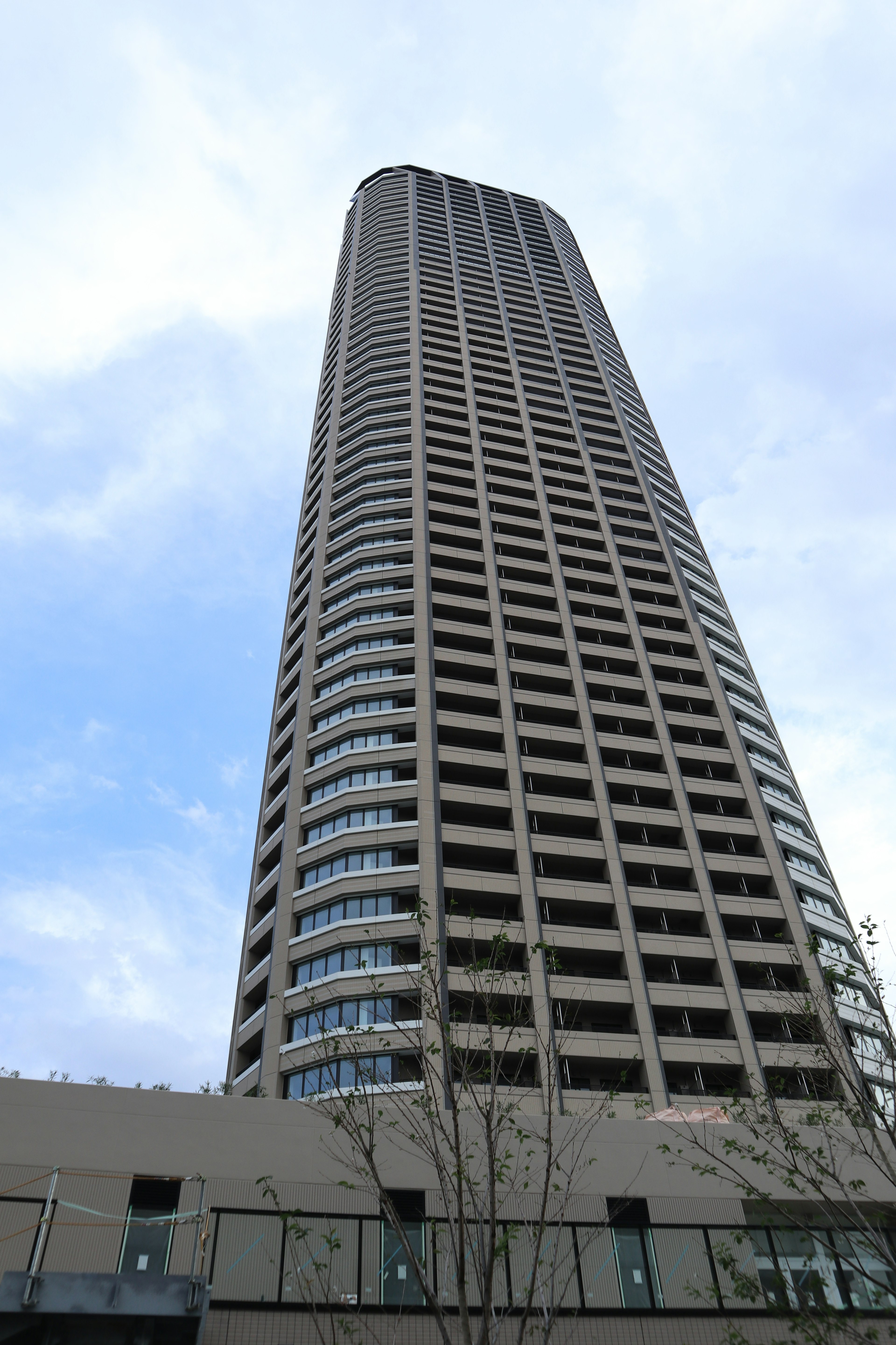 高層ビルの下からの視点で青い空を背景にした建物の外観