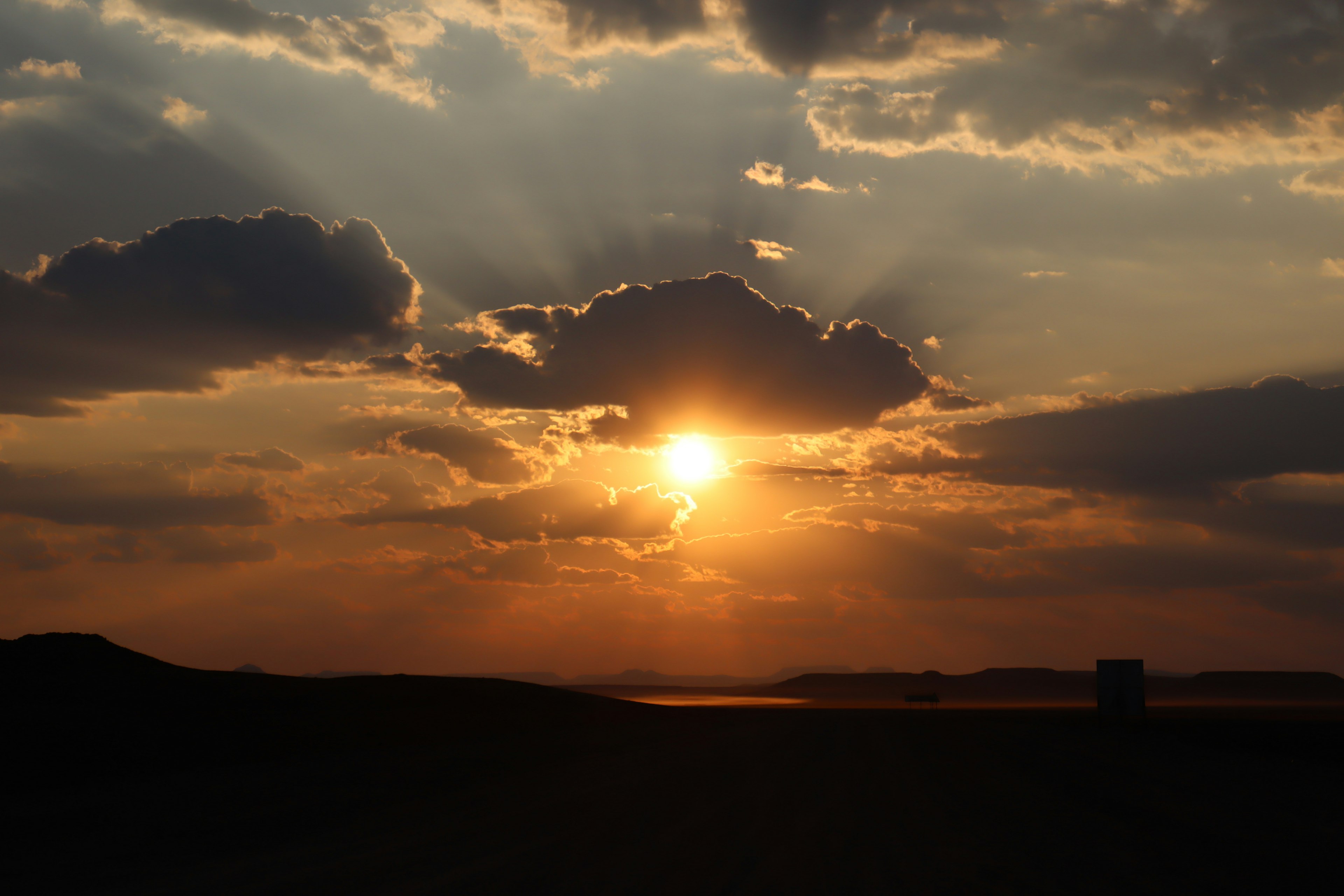 Schöne Landschaft mit der Sonne, die durch die Wolken beim Sonnenuntergang scheint