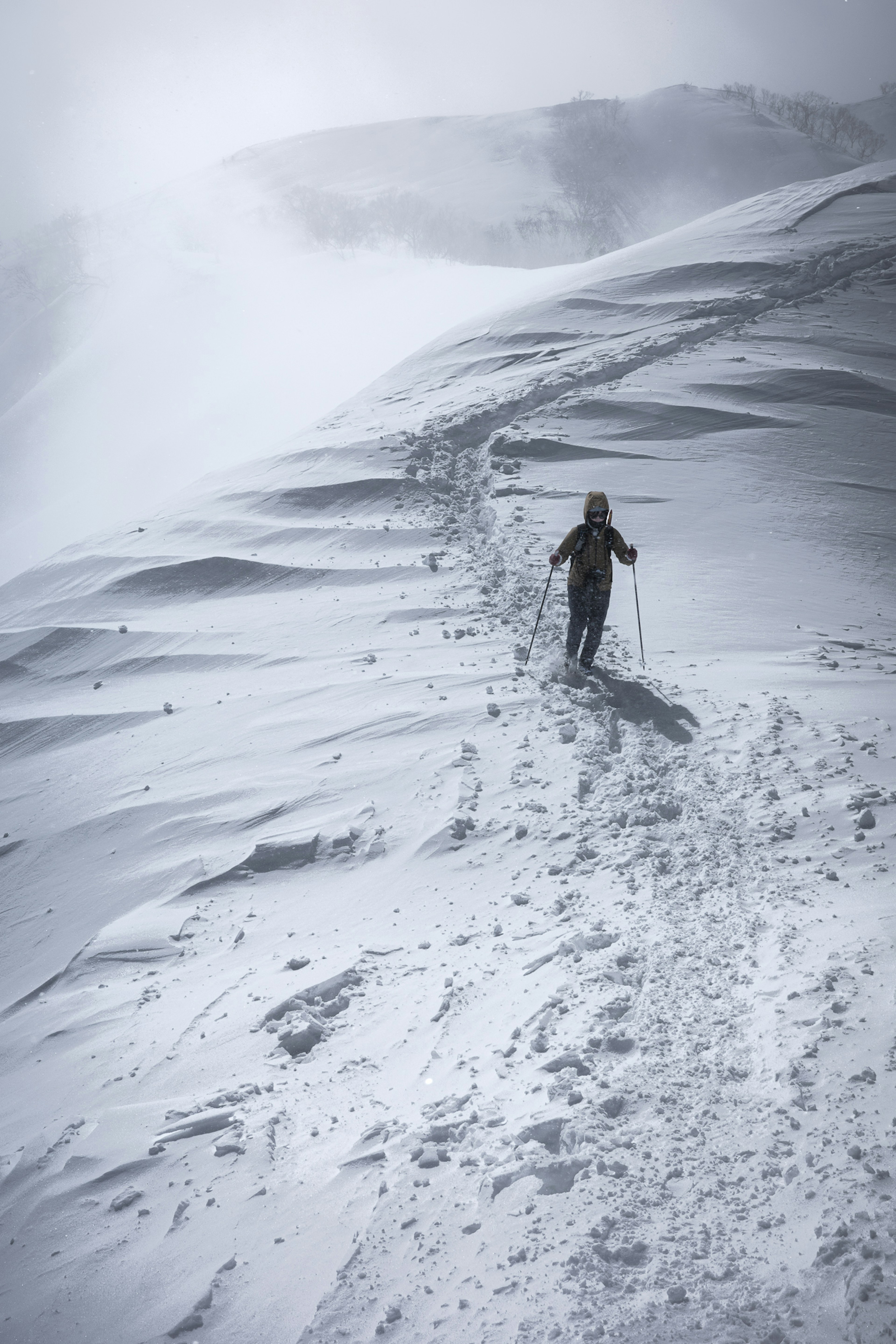 Ein Skifahrer, der einen schneebedeckten Berg hinaufsteigt