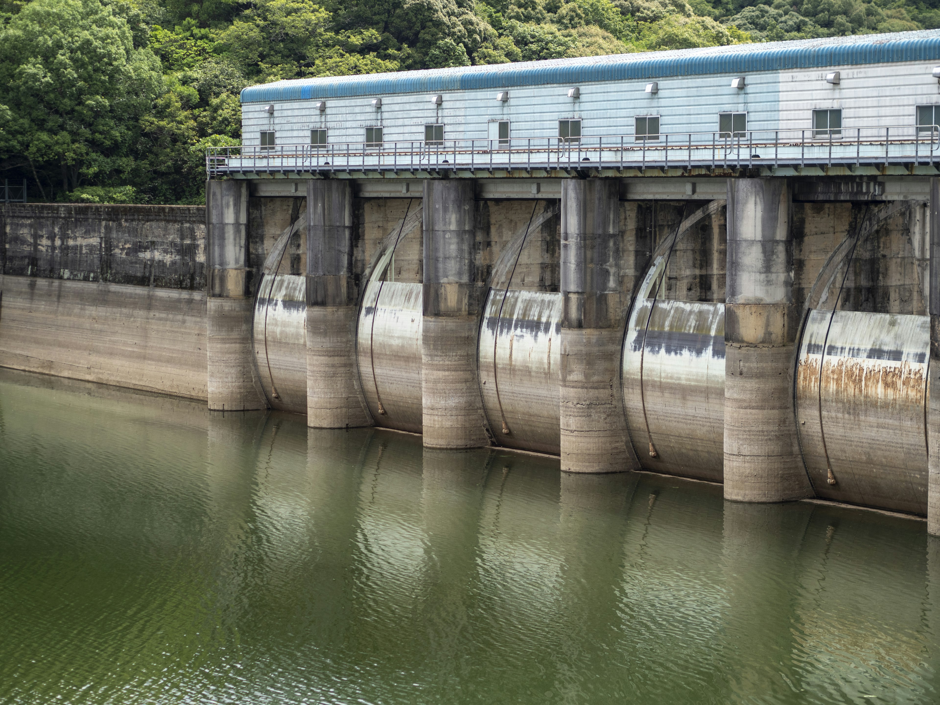 大坝溢洪道与宁静水面及周围绿树