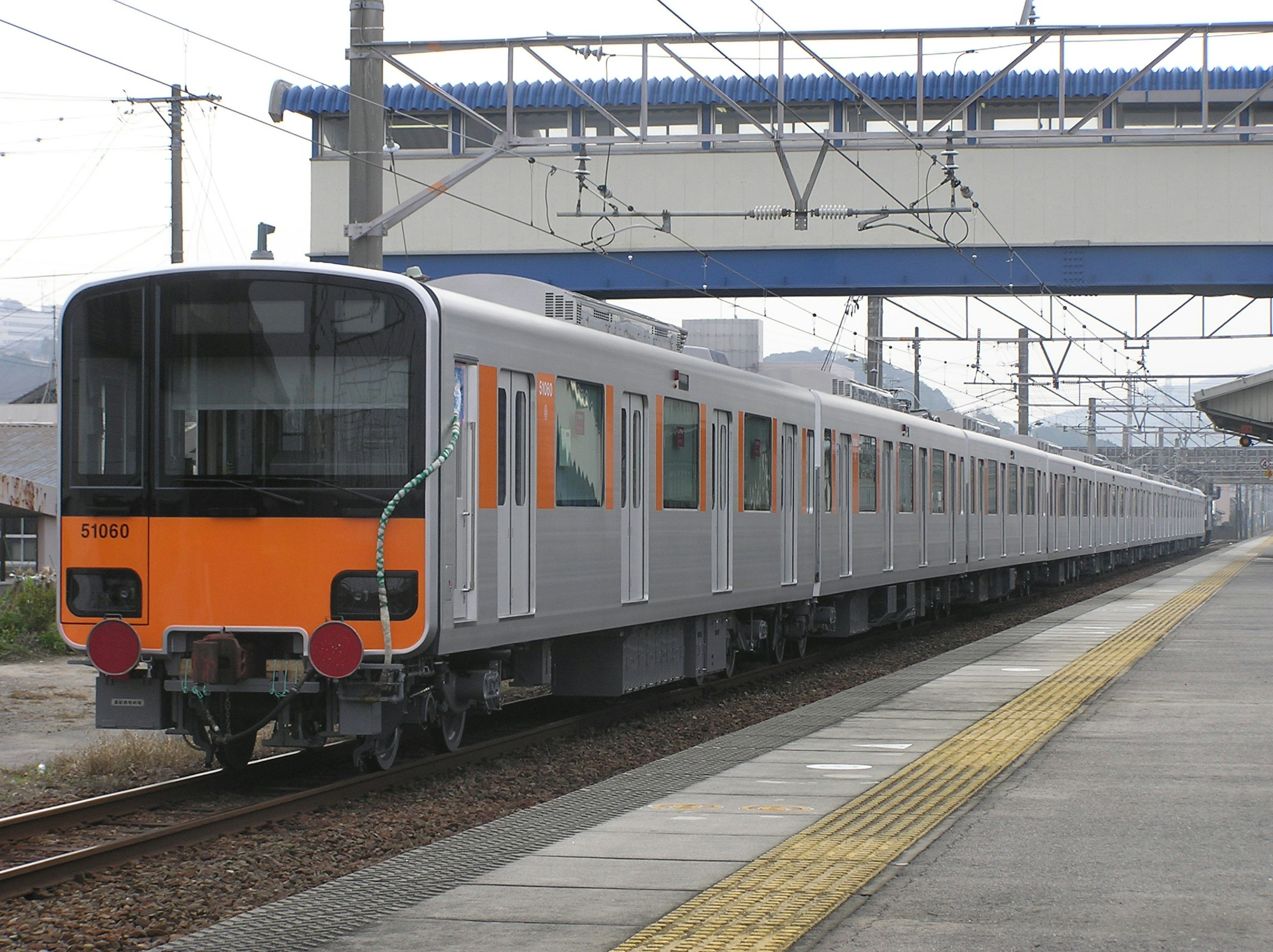 Treno arancione e argento parcheggiato in una stazione