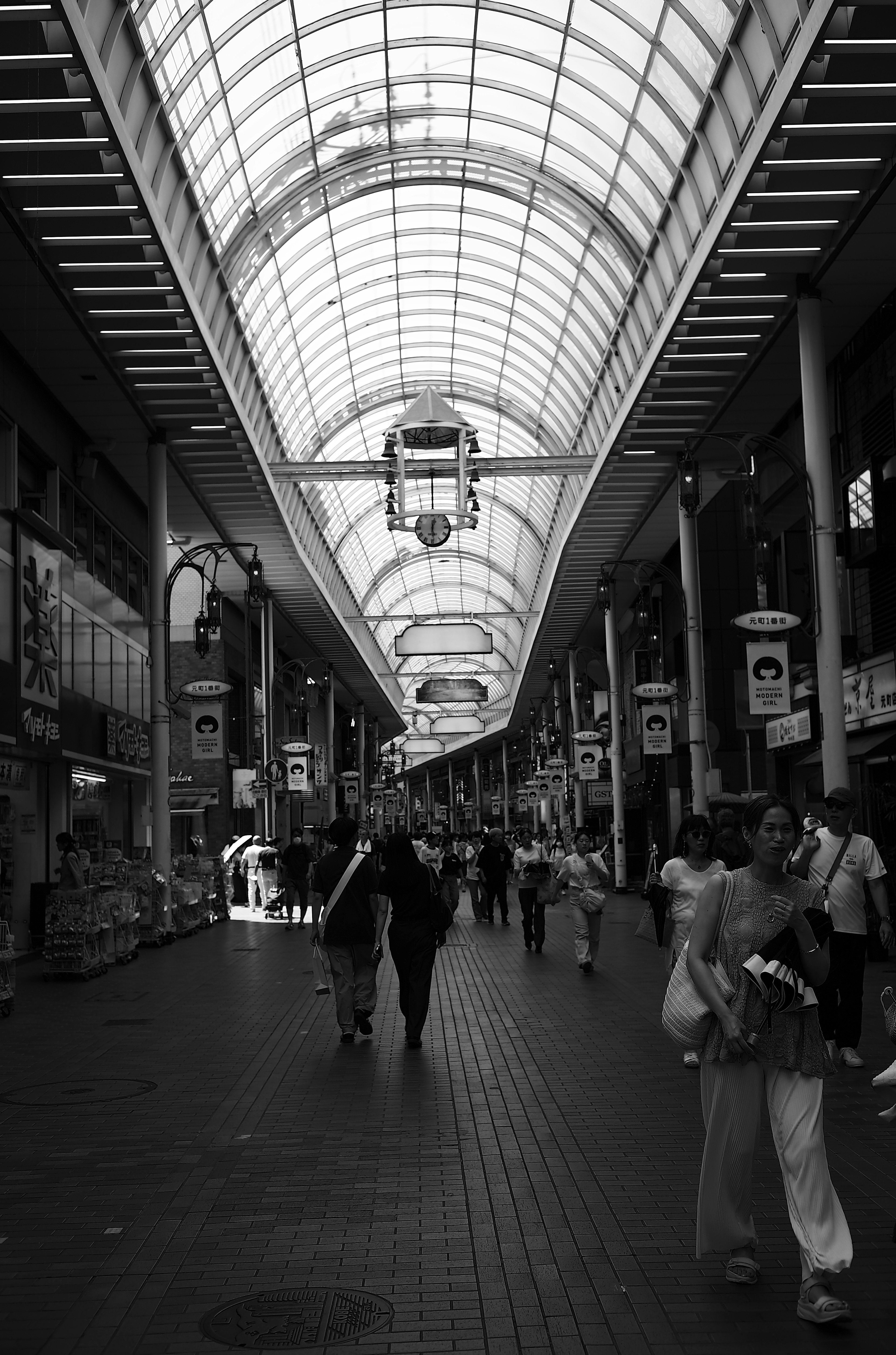 Arcada comercial en blanco y negro con personas caminando