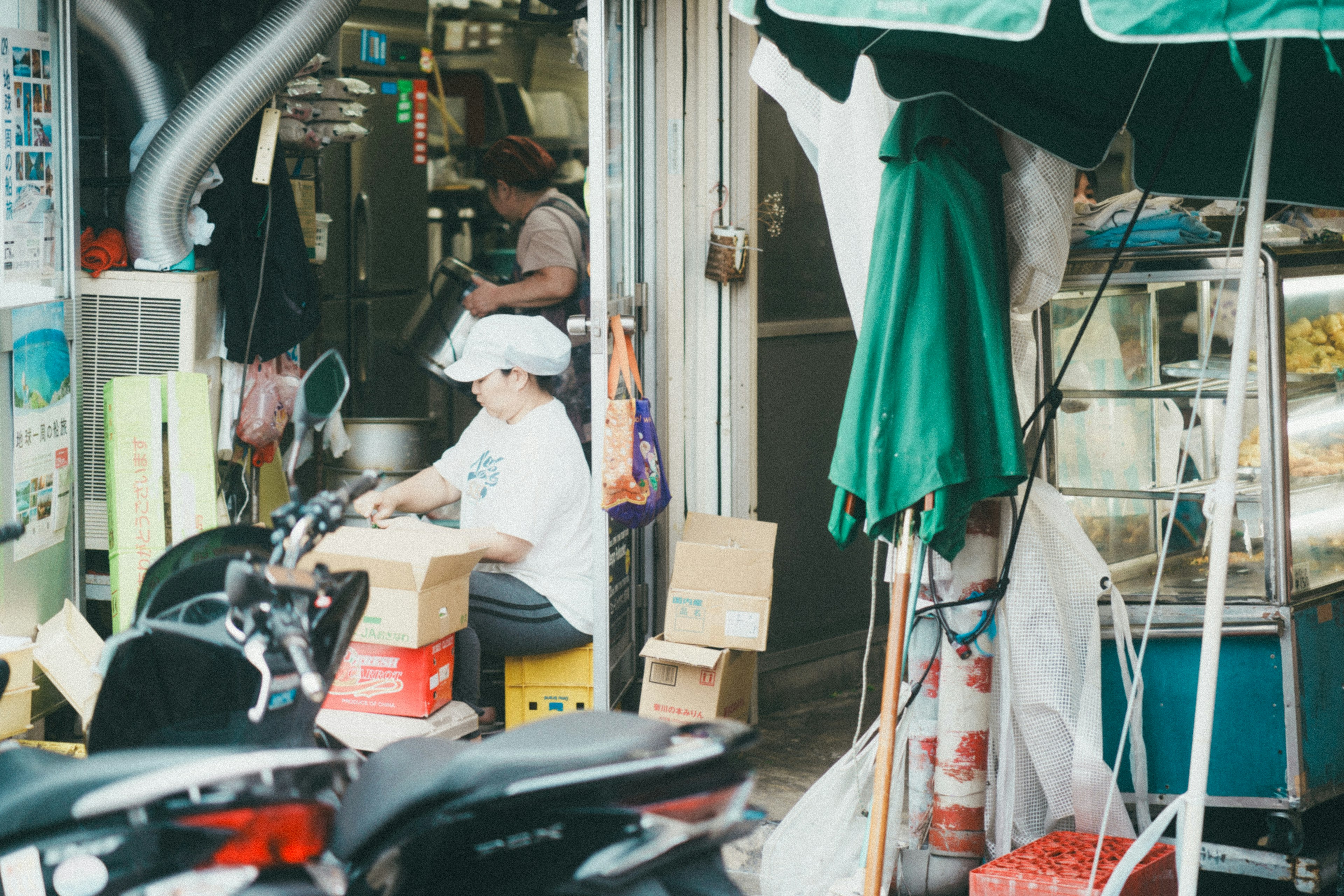 Personne travaillant près d'un stand de nourriture avec des motos et des boîtes environnantes