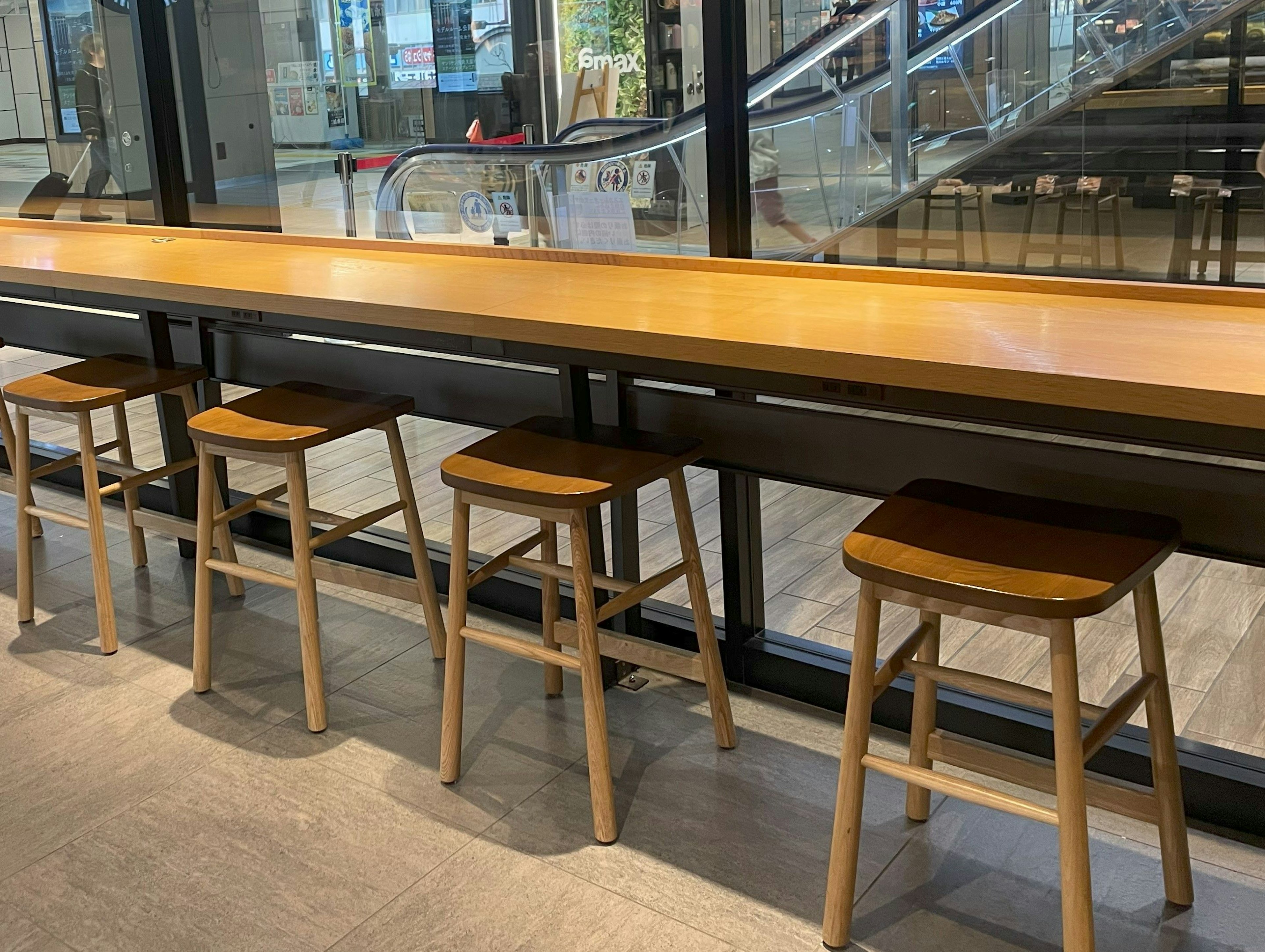 Modern café interior with a wooden counter table and stools