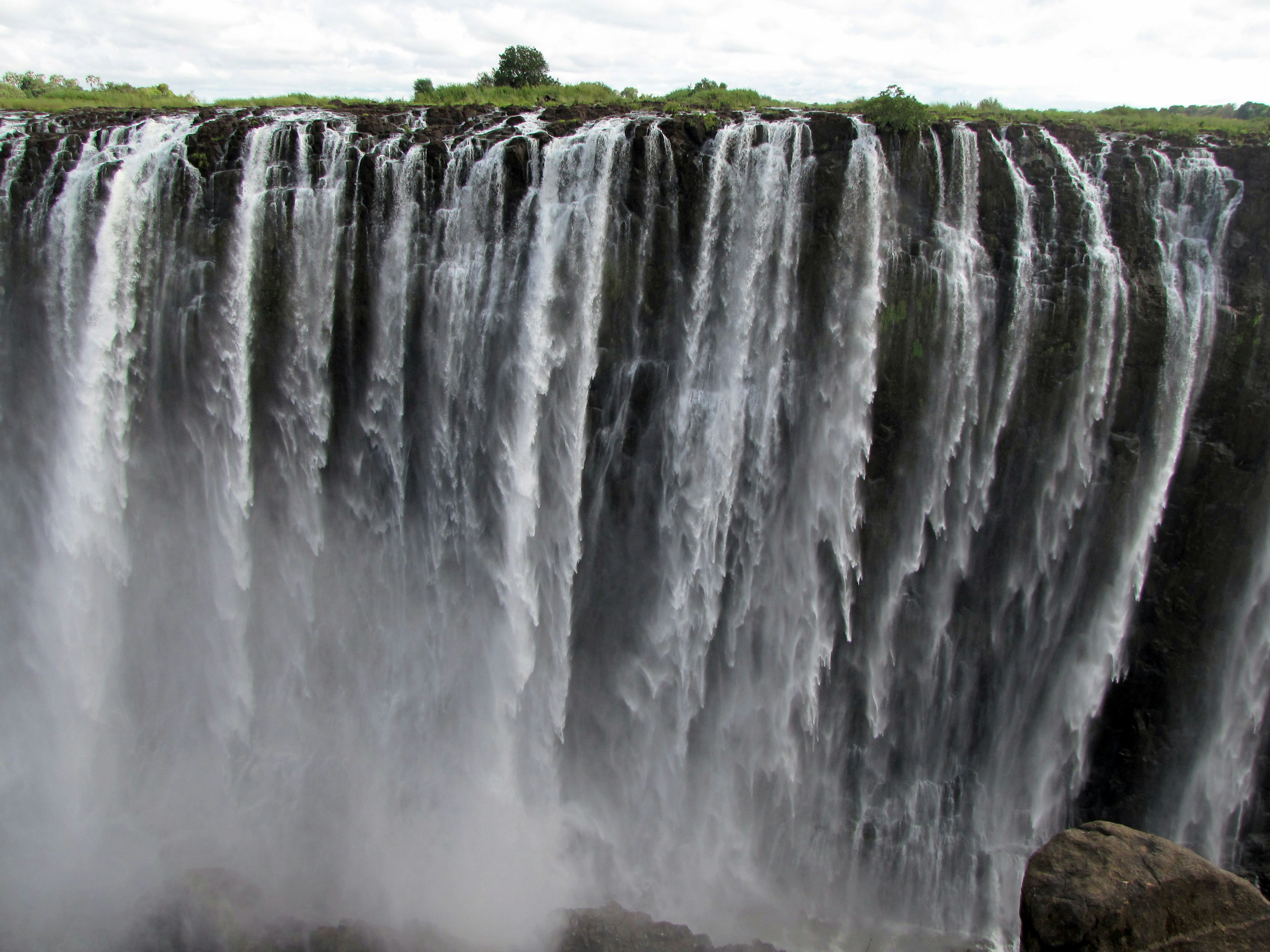 Vista maestosa della cascata con acqua che scorre e nebbia