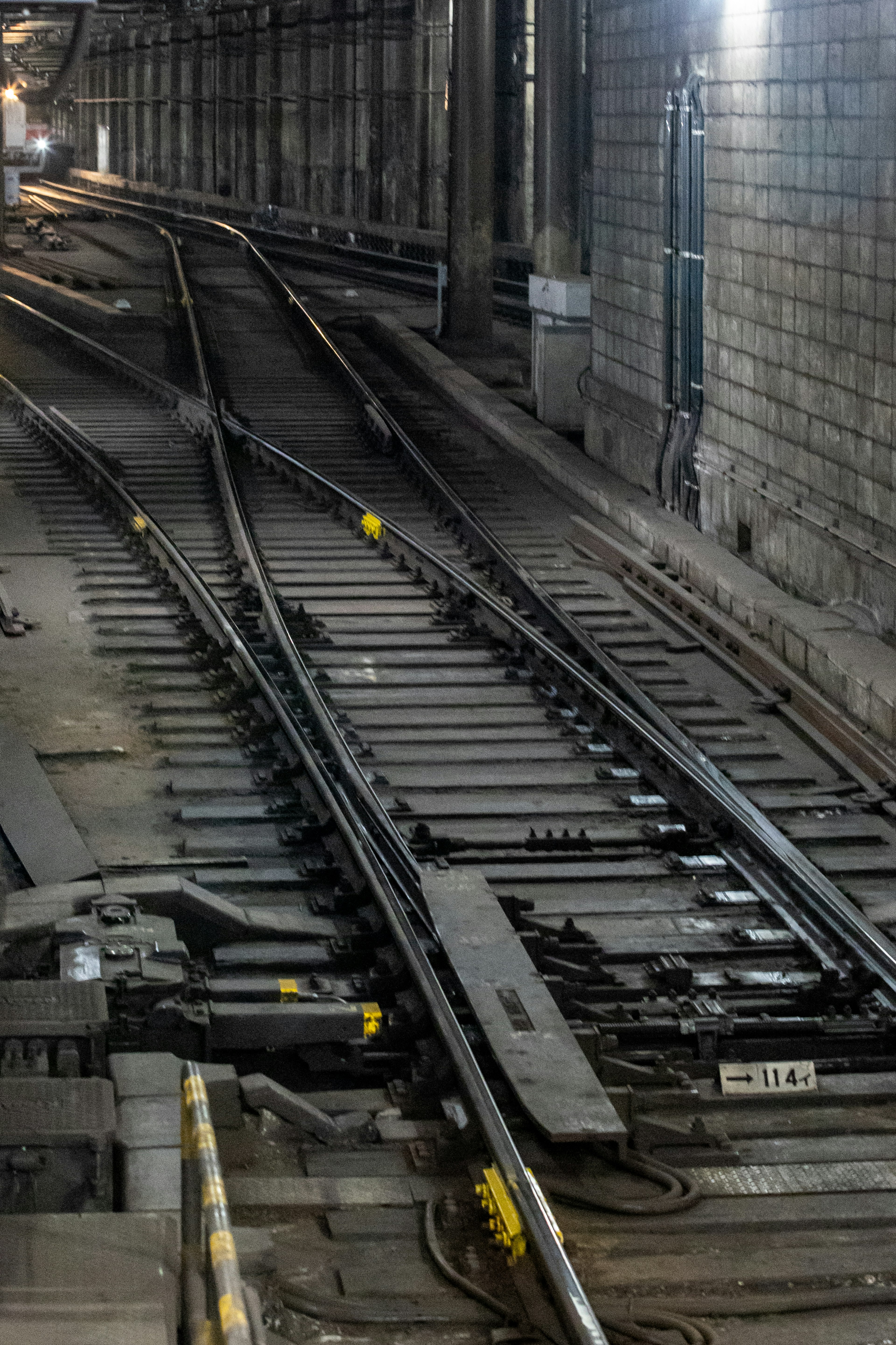 Binari della metropolitana che si incrociano in un tunnel poco illuminato