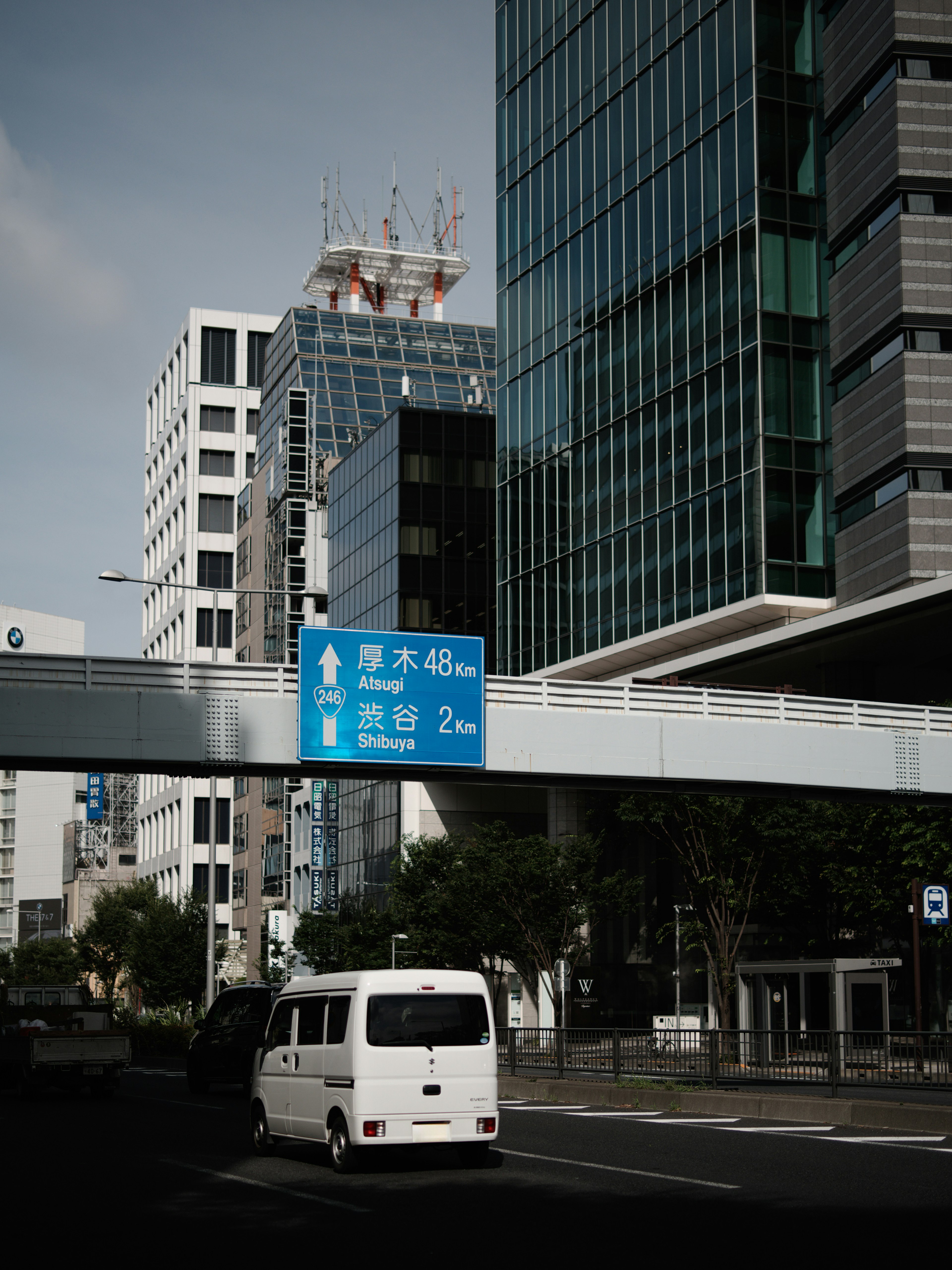 Urban scene featuring tall buildings and a blue directional sign