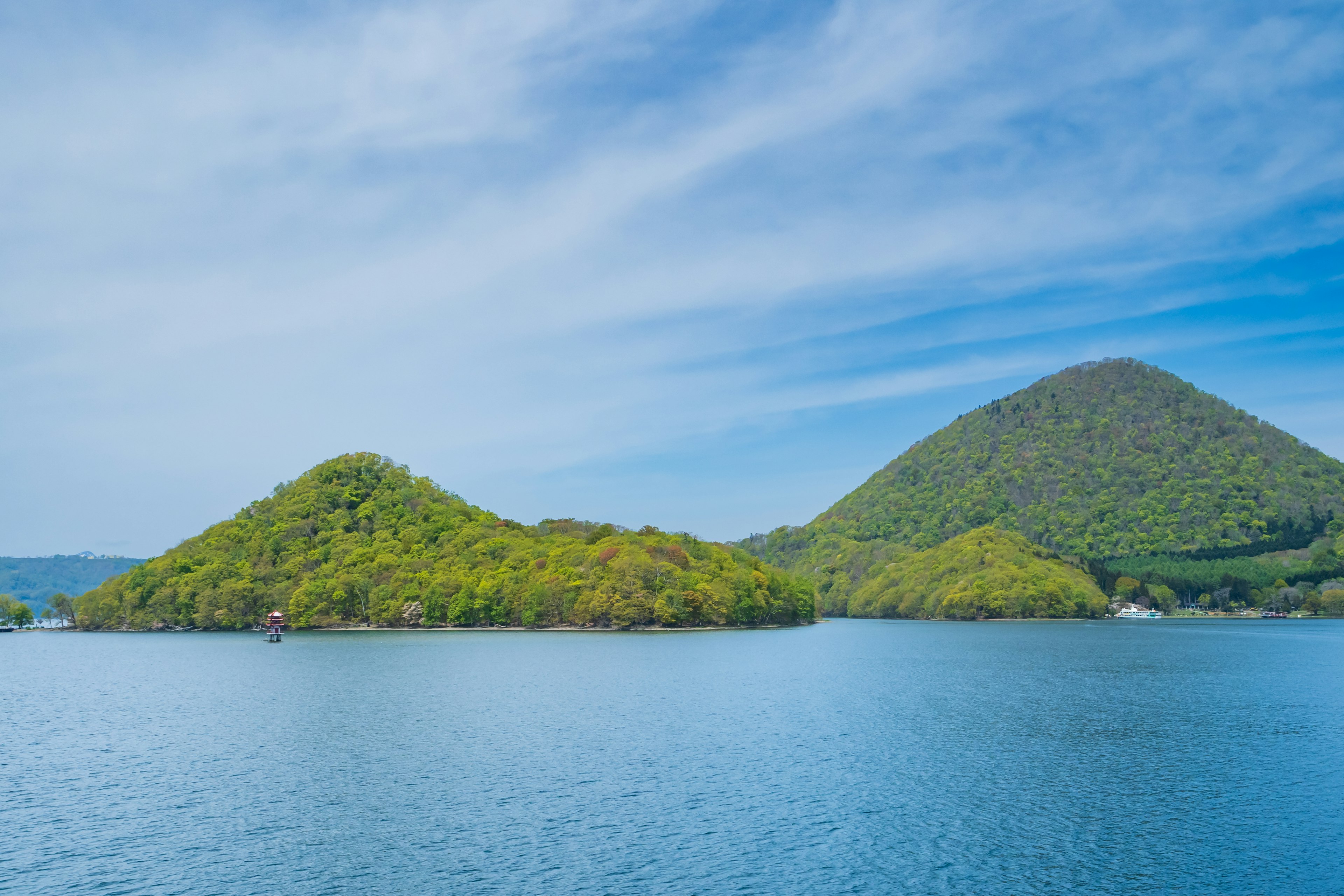 Vue pittoresque de collines vertes et d'eau bleue sous un ciel clair