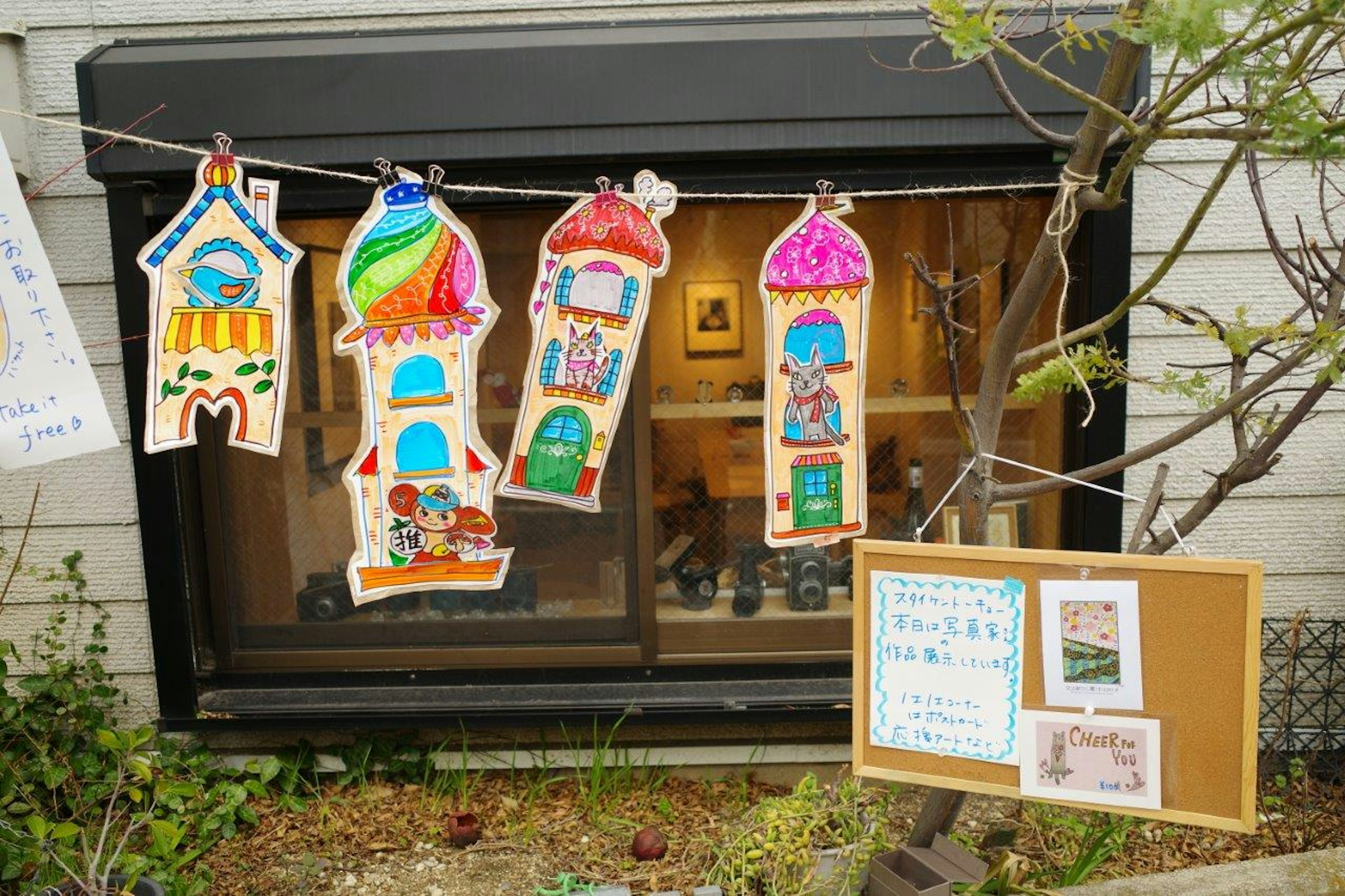 Colorful handmade house decorations hanging in front of a window