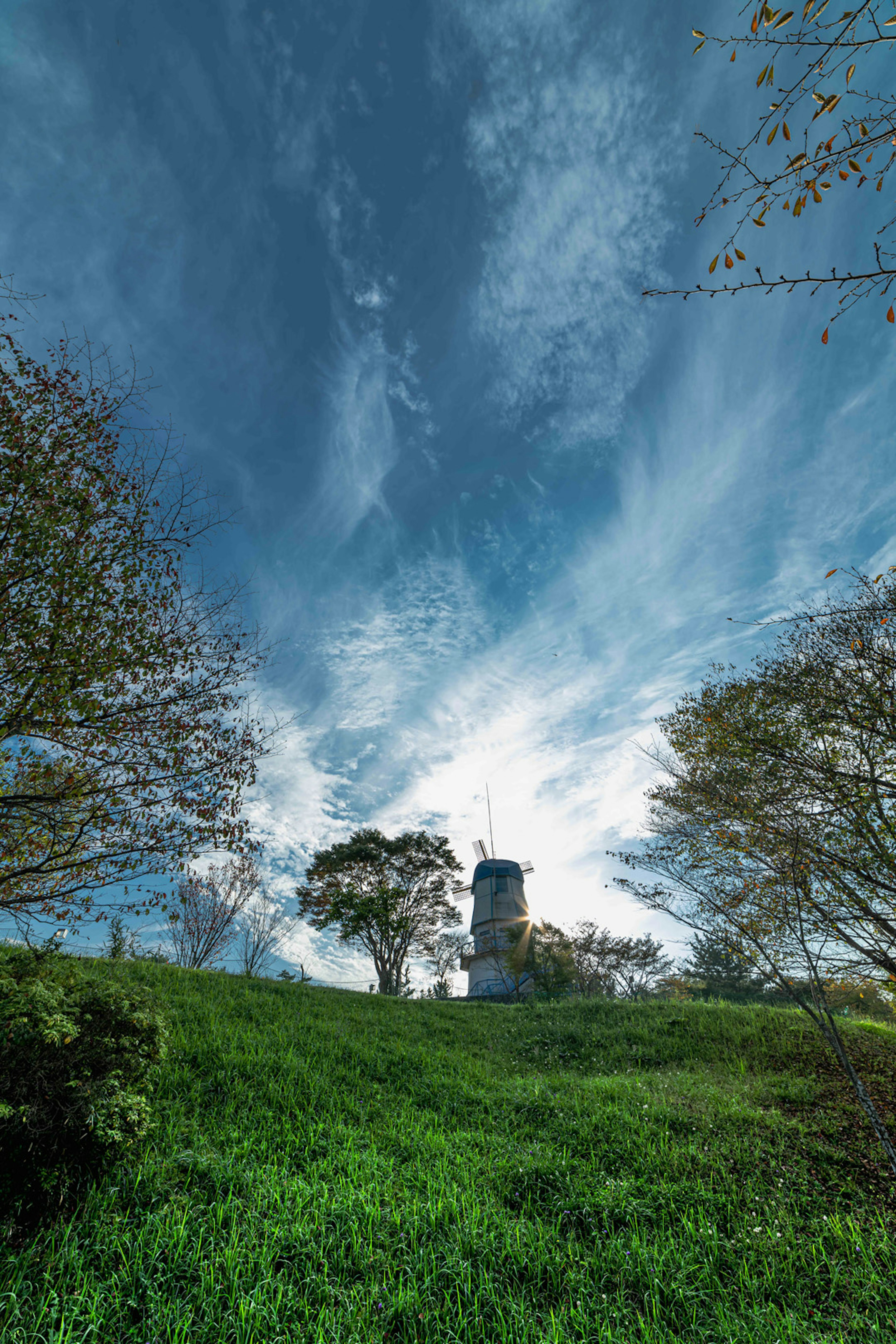 Tour sur une colline verte sous un ciel bleu avec des nuages