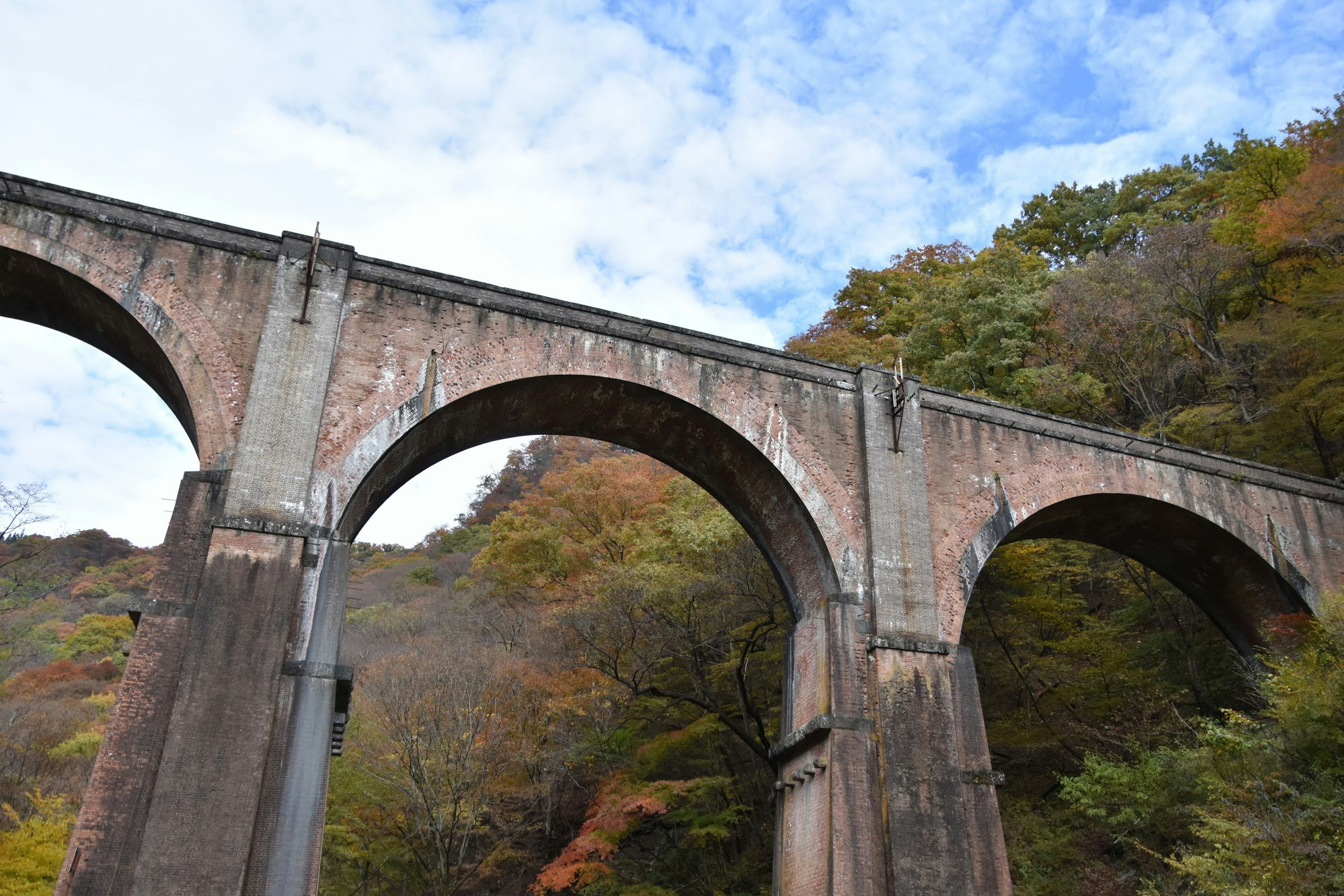 Ancien pont en arc en béton entouré par un magnifique paysage automnal