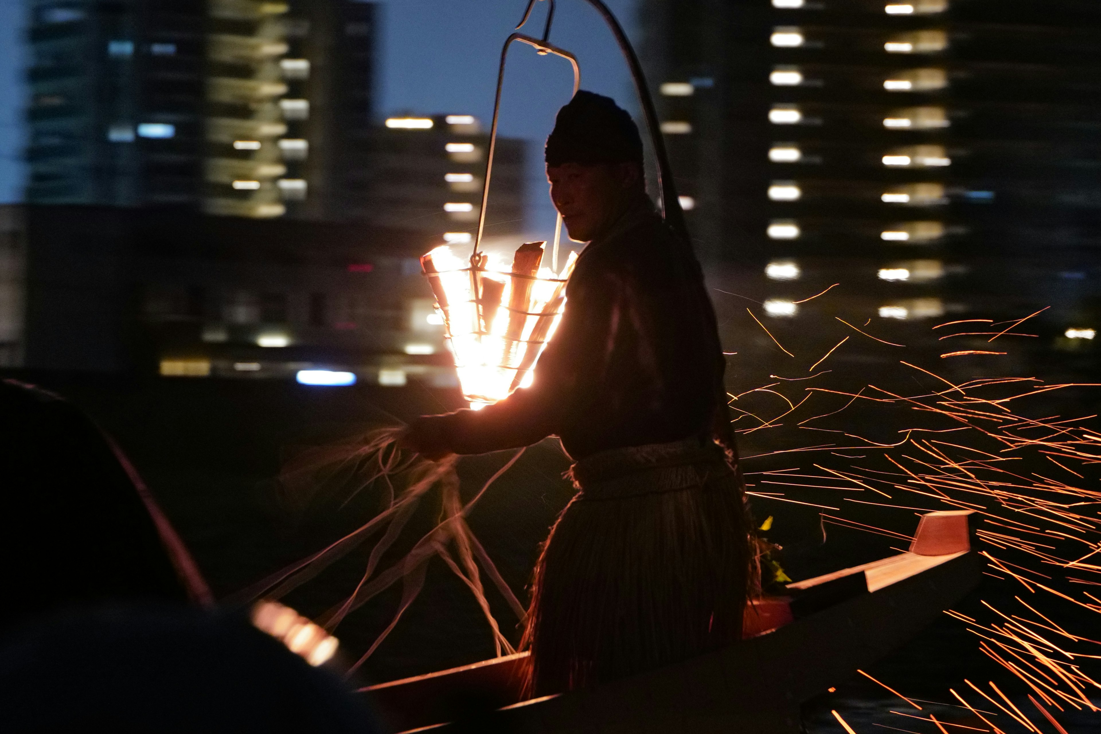 夜の都市で火花を散らす漁師のシルエット