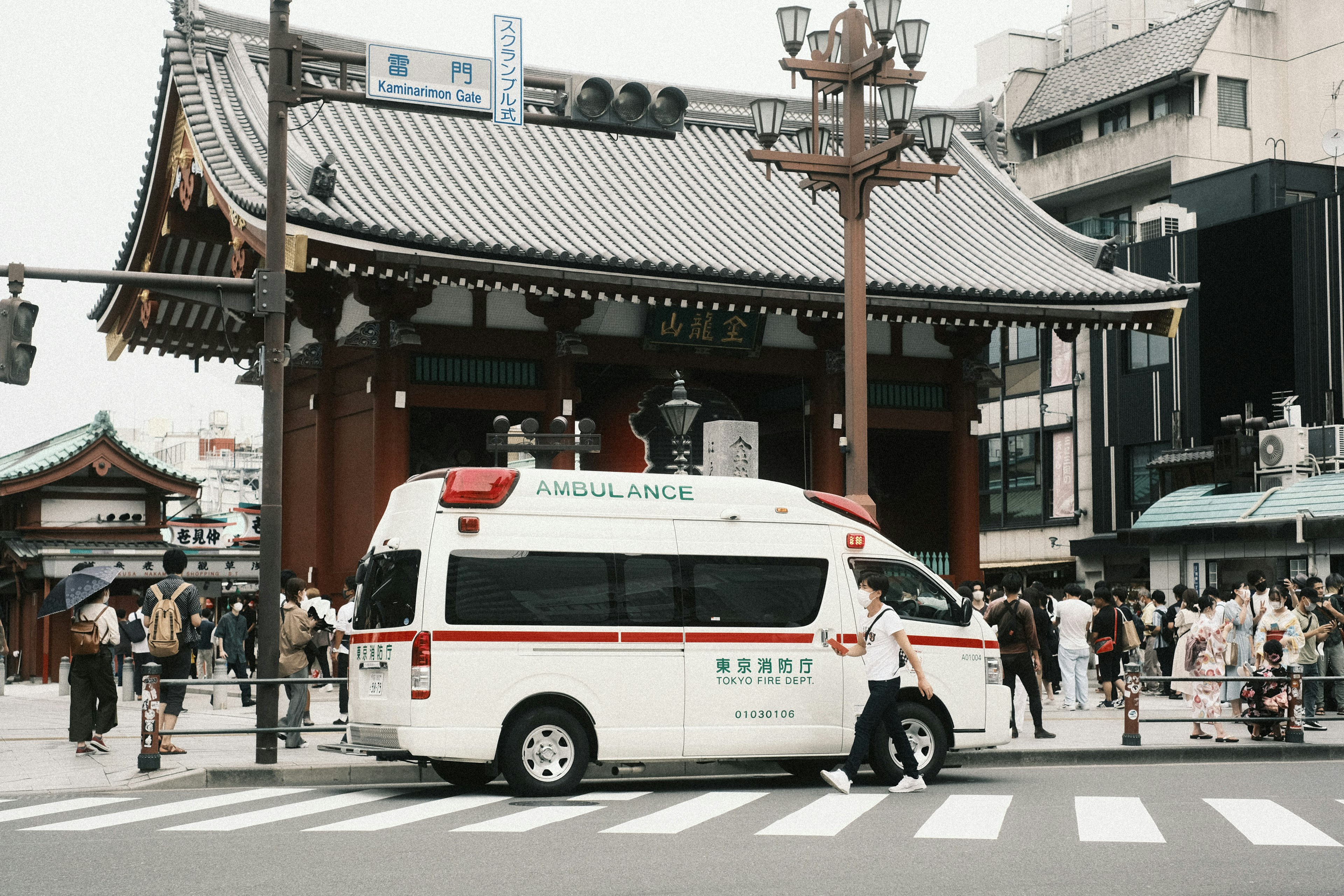 Ambulanza parcheggiata di fronte al tempio Senso-ji con pedoni circostanti