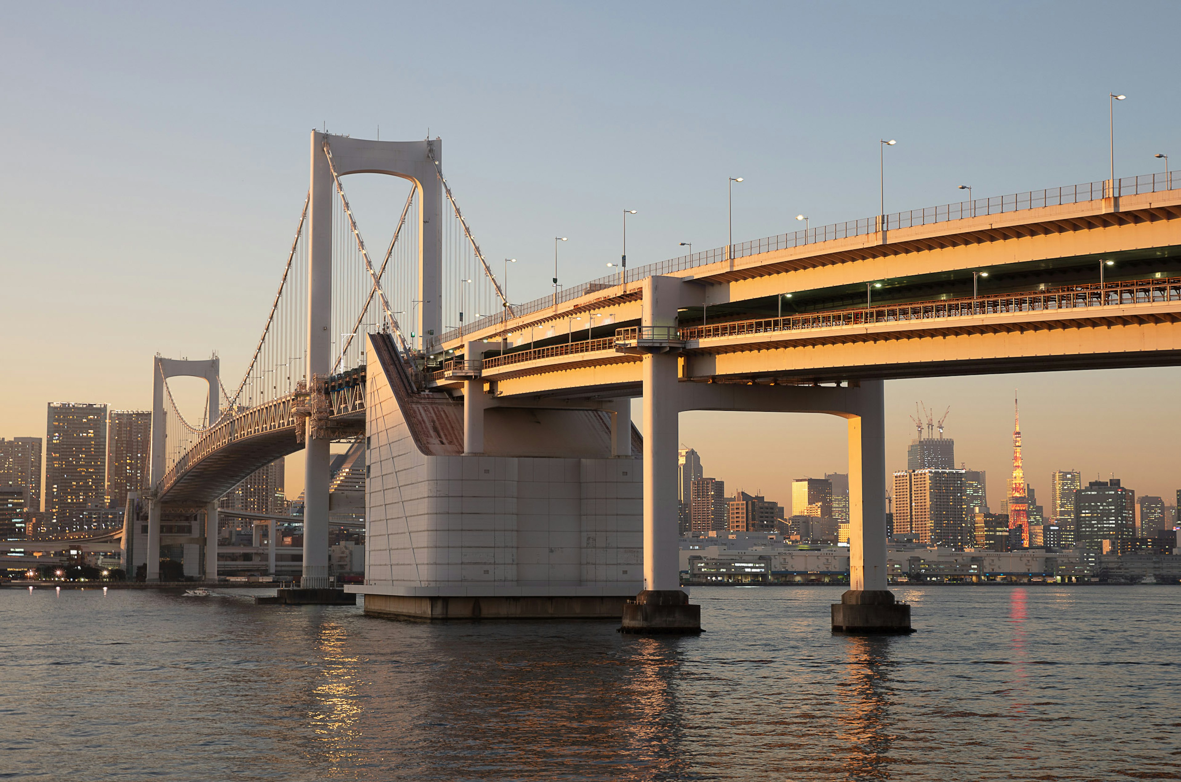 Pont Rainbow à Tokyo avec la ligne d'horizon de la ville au coucher du soleil