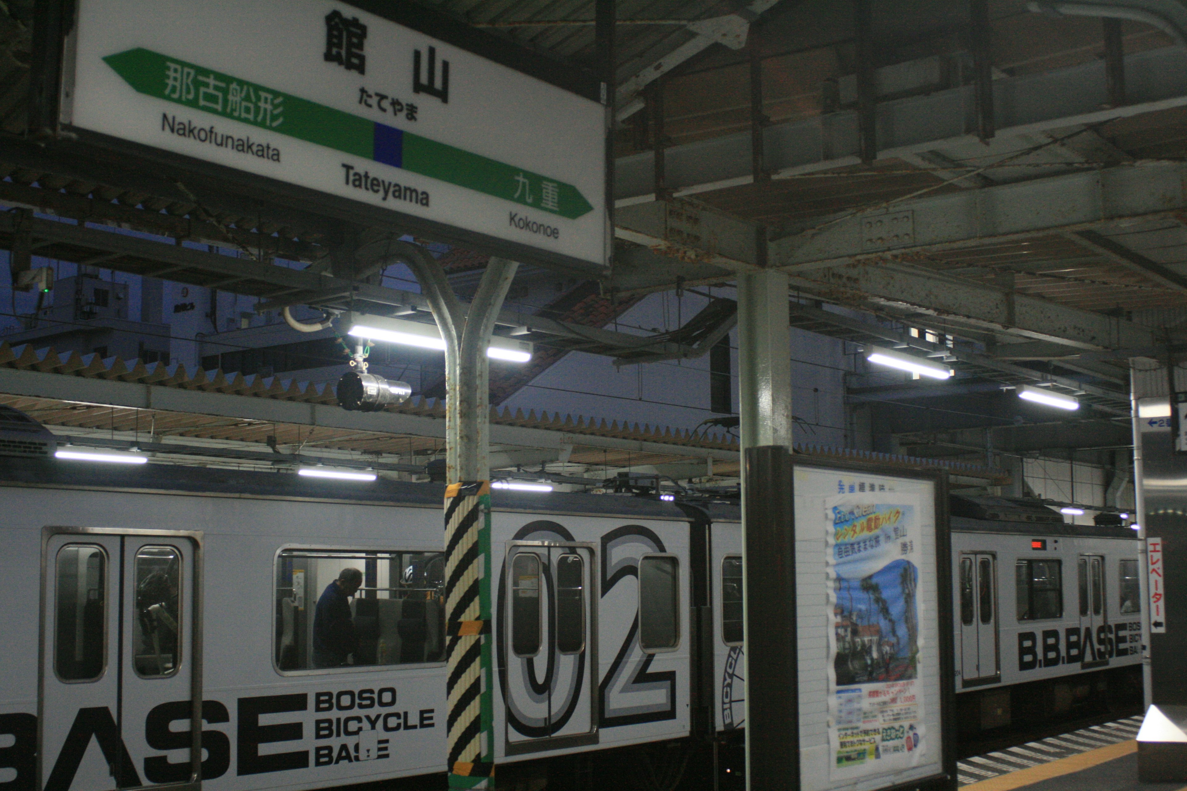 Night view of a train station with signage and train