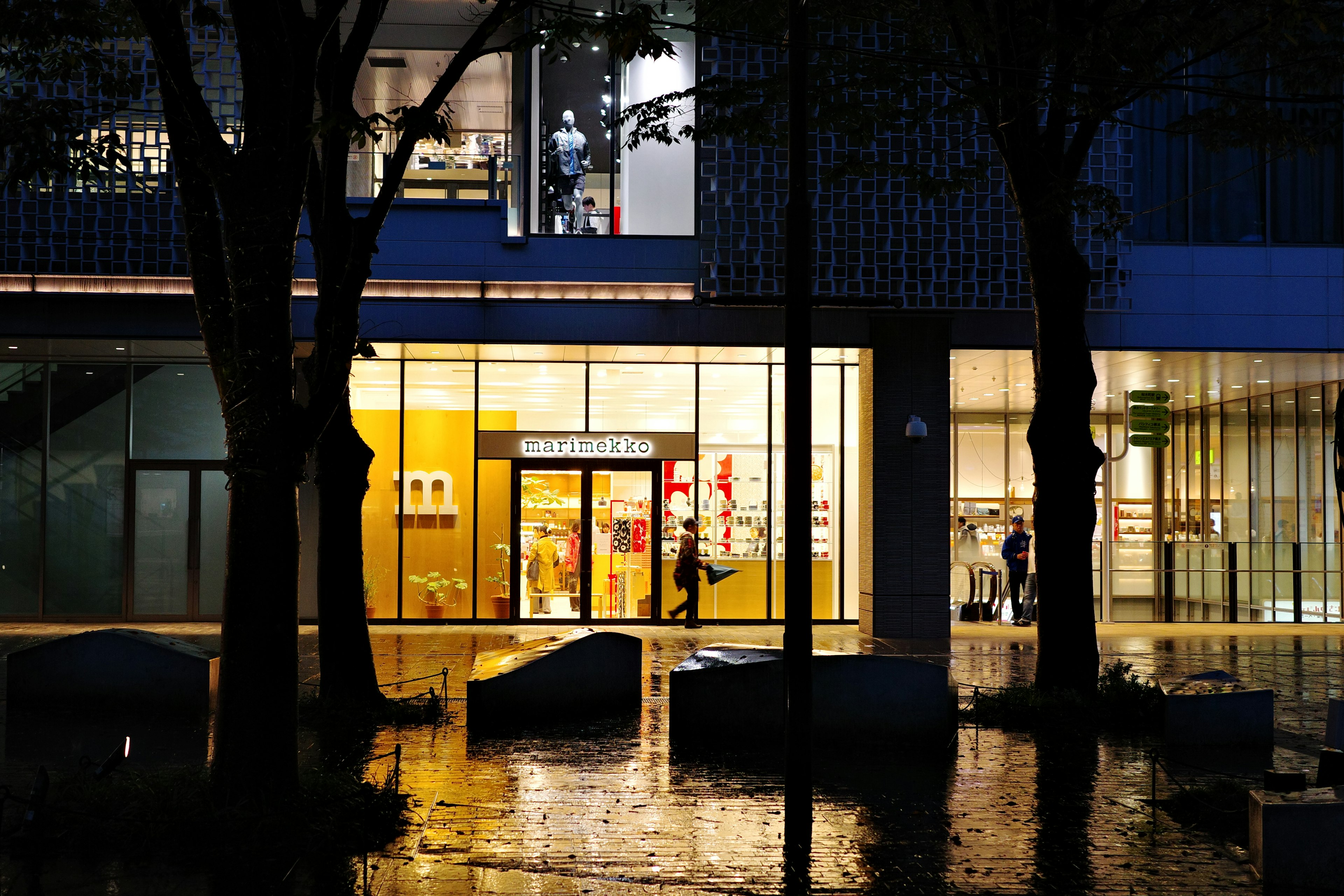 雨の中の明るい店舗の外観と反射