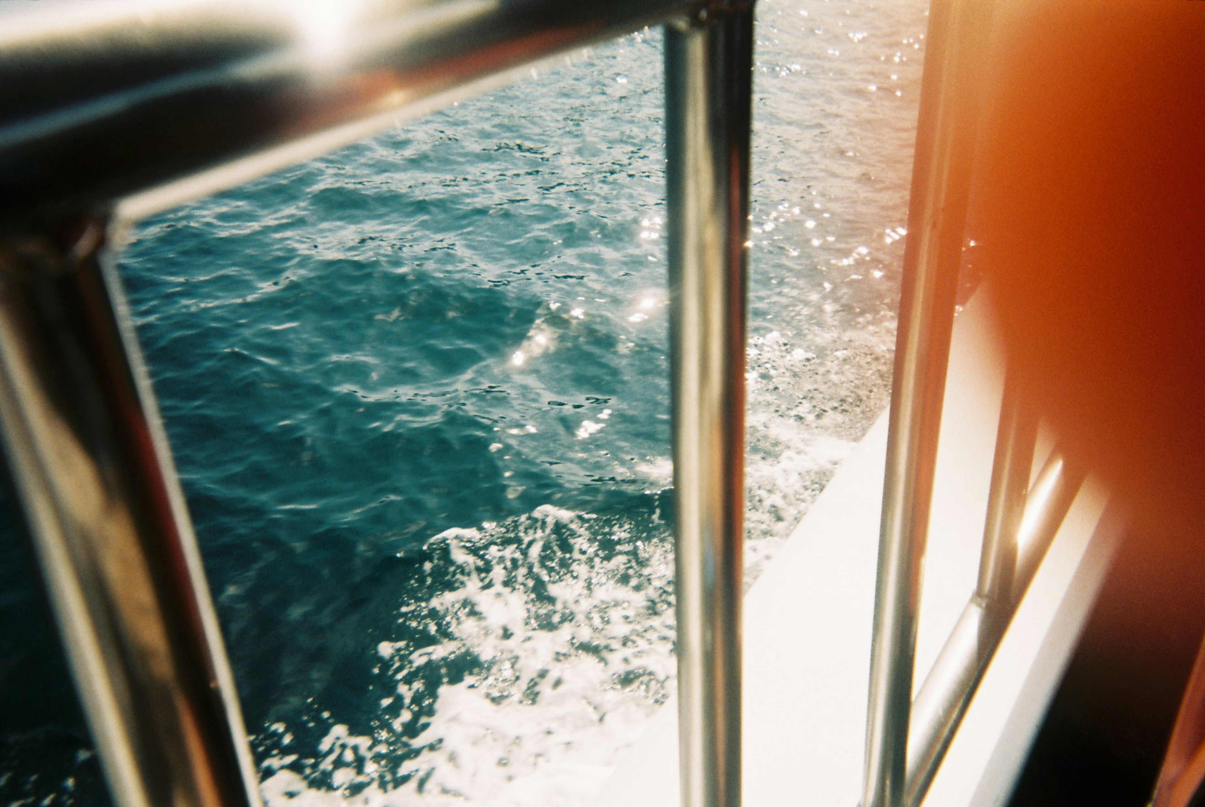 Imagen de un pasamanos de barco con olas del océano