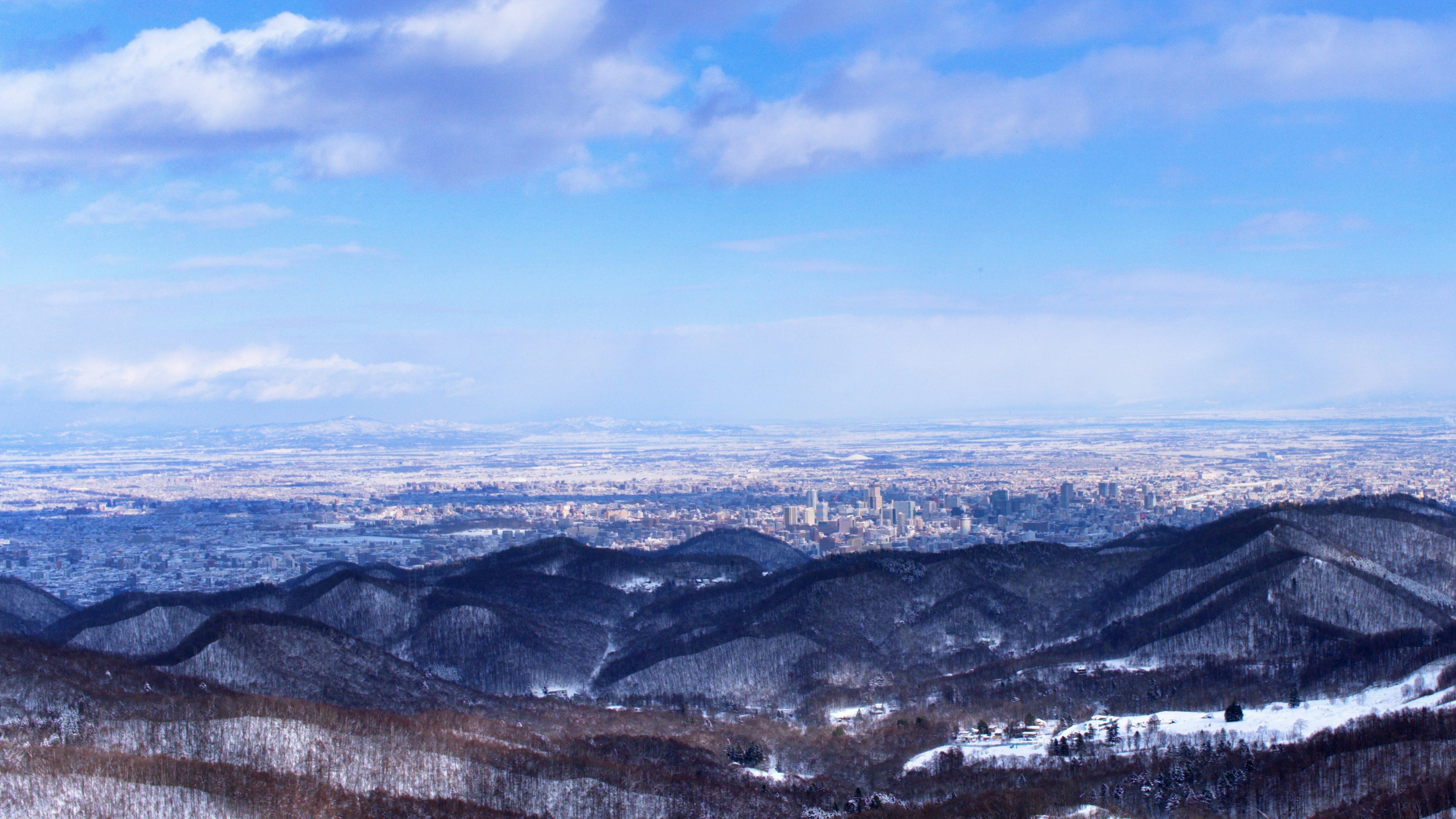 Snow-covered mountains under a vast blue sky