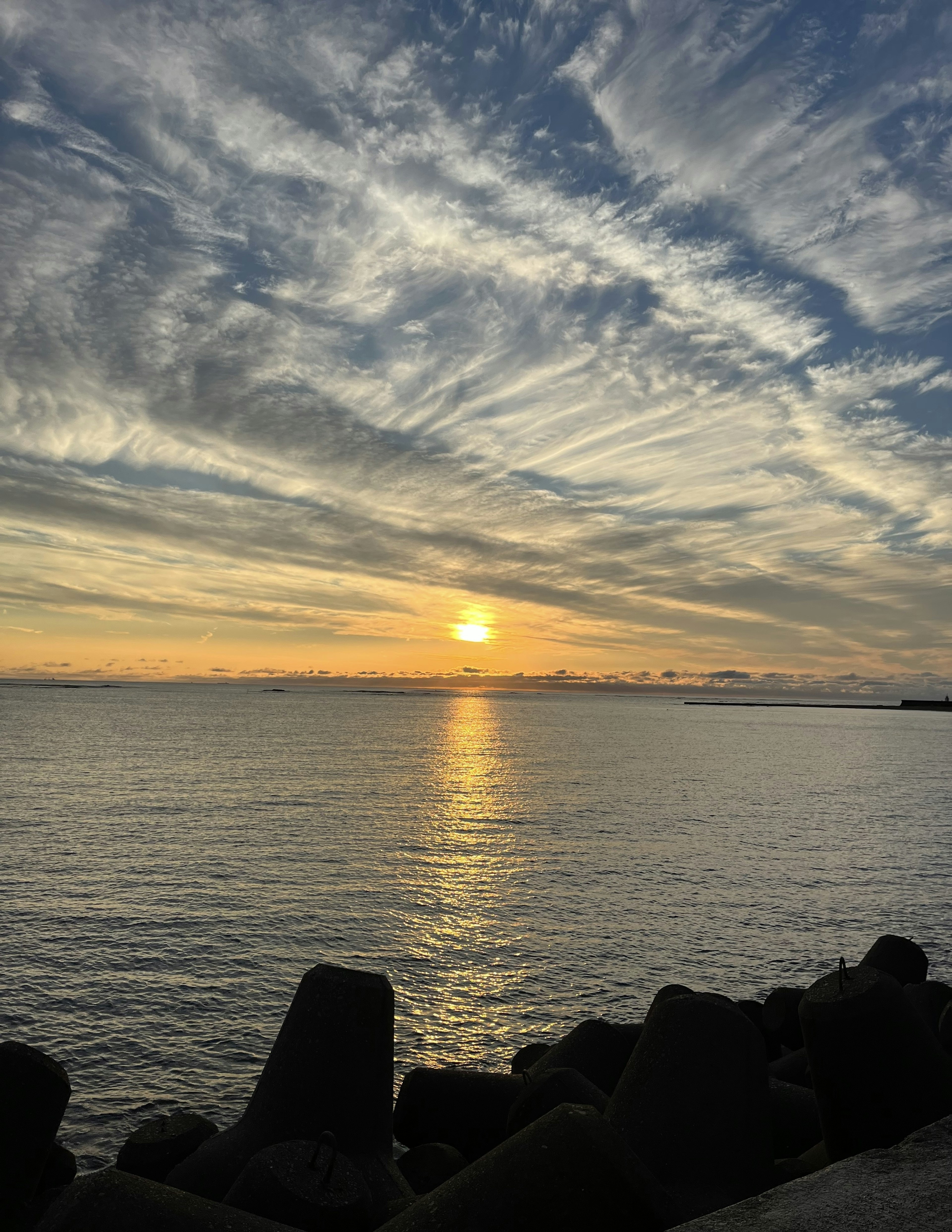 Sonnenuntergang über dem Ozean mit einem wolkenverhangenen Himmel