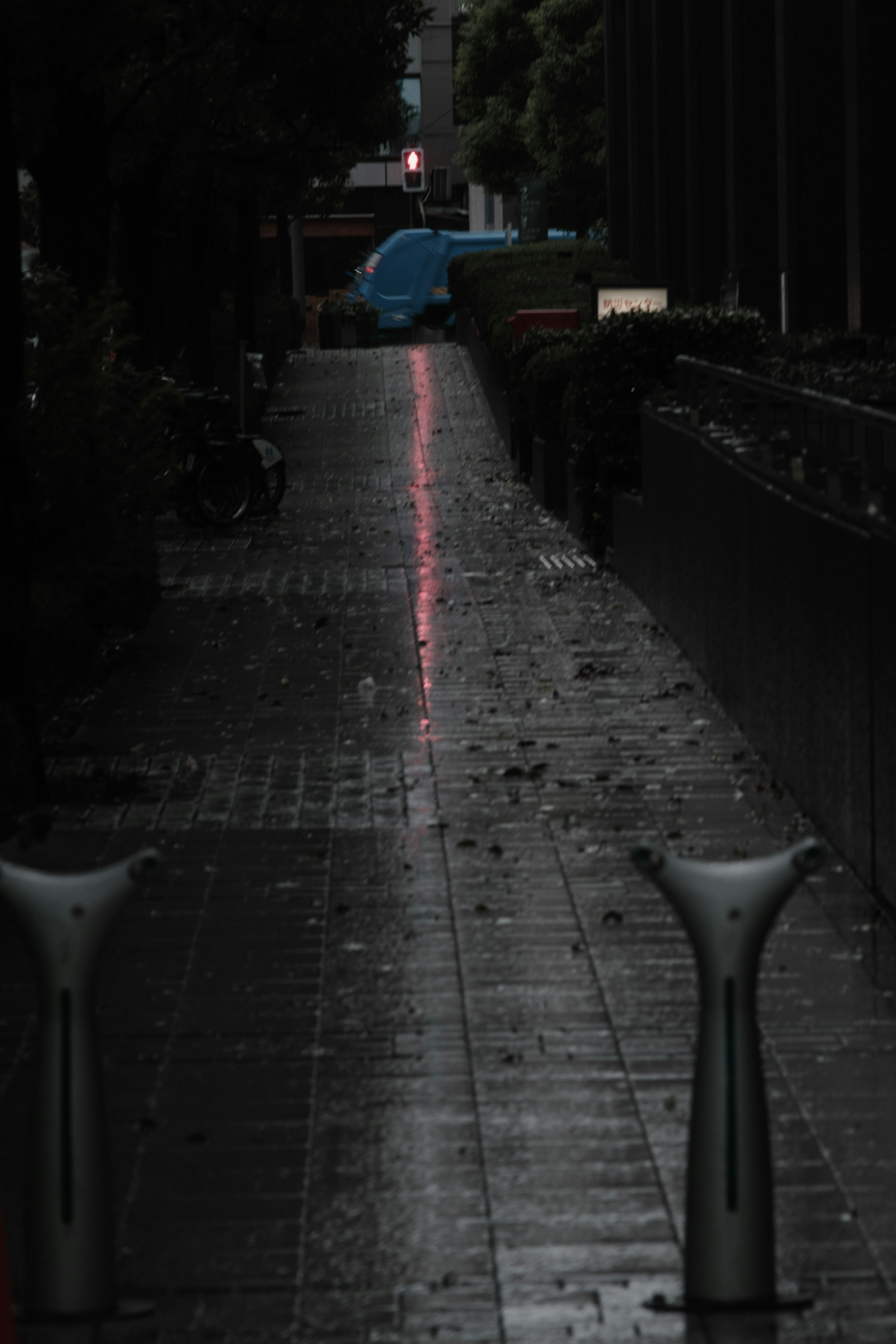 Ruhige Straße mit nassem Gehweg, der das Licht reflektiert