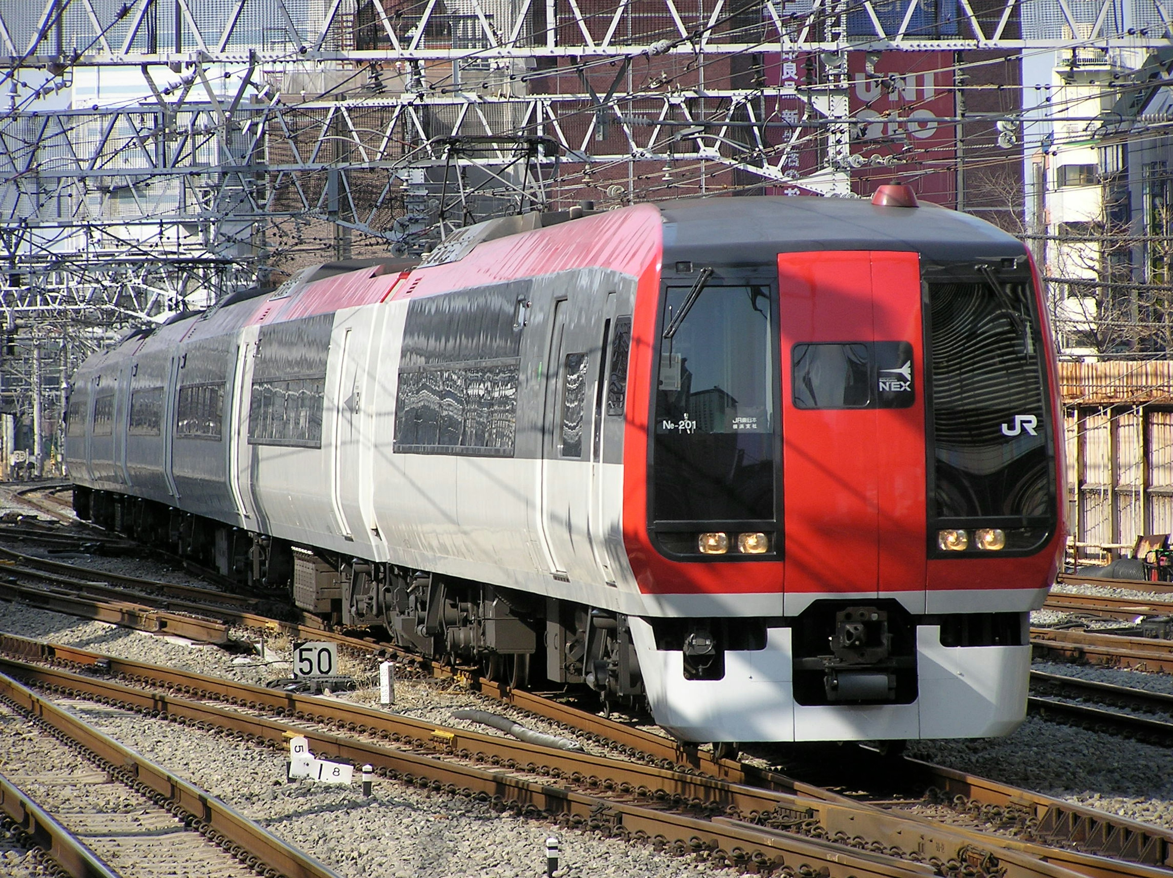 赤と白のデザインのJR列車が線路上に停車している