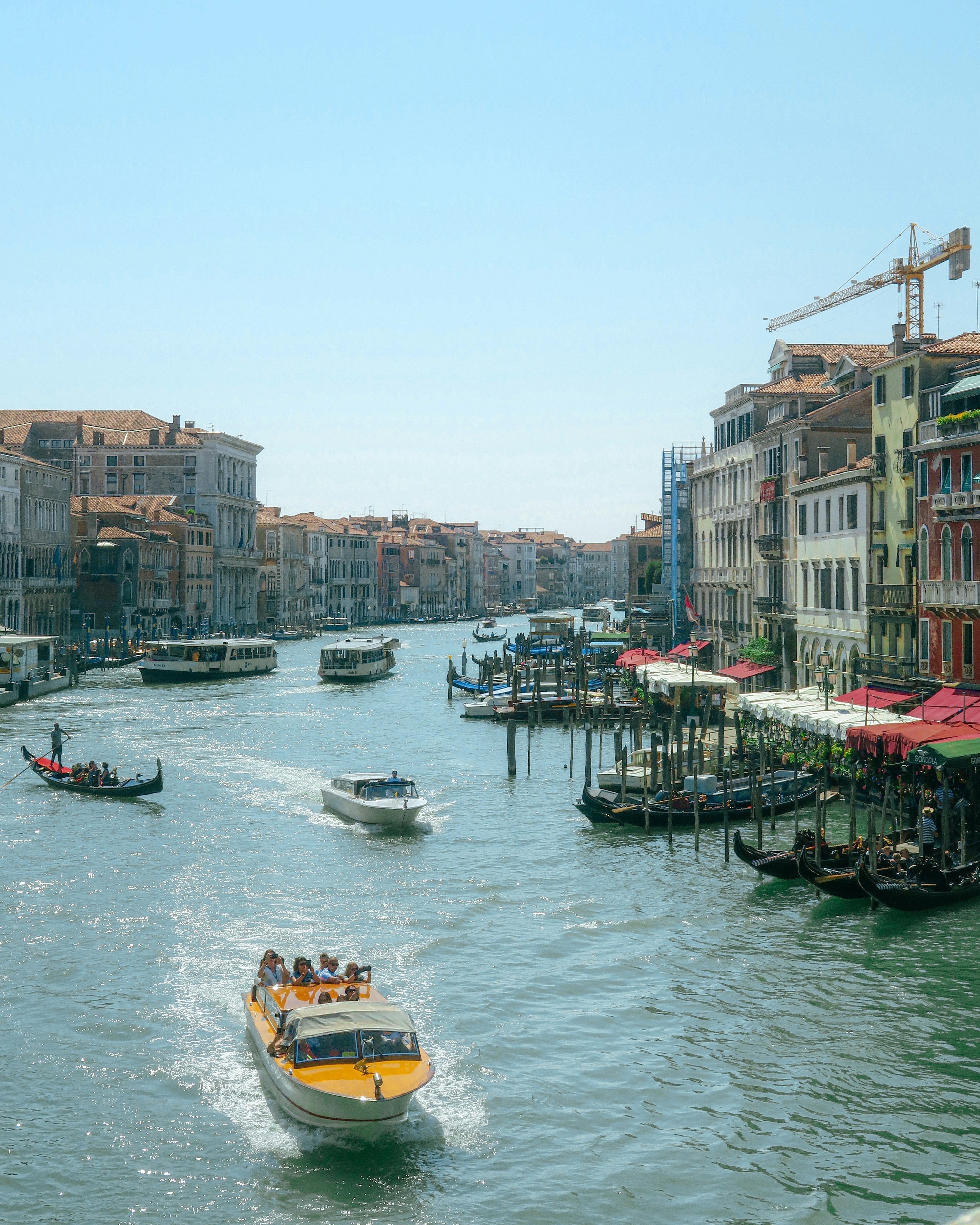 Vista de un canal en Venecia con un bote amarillo navegando