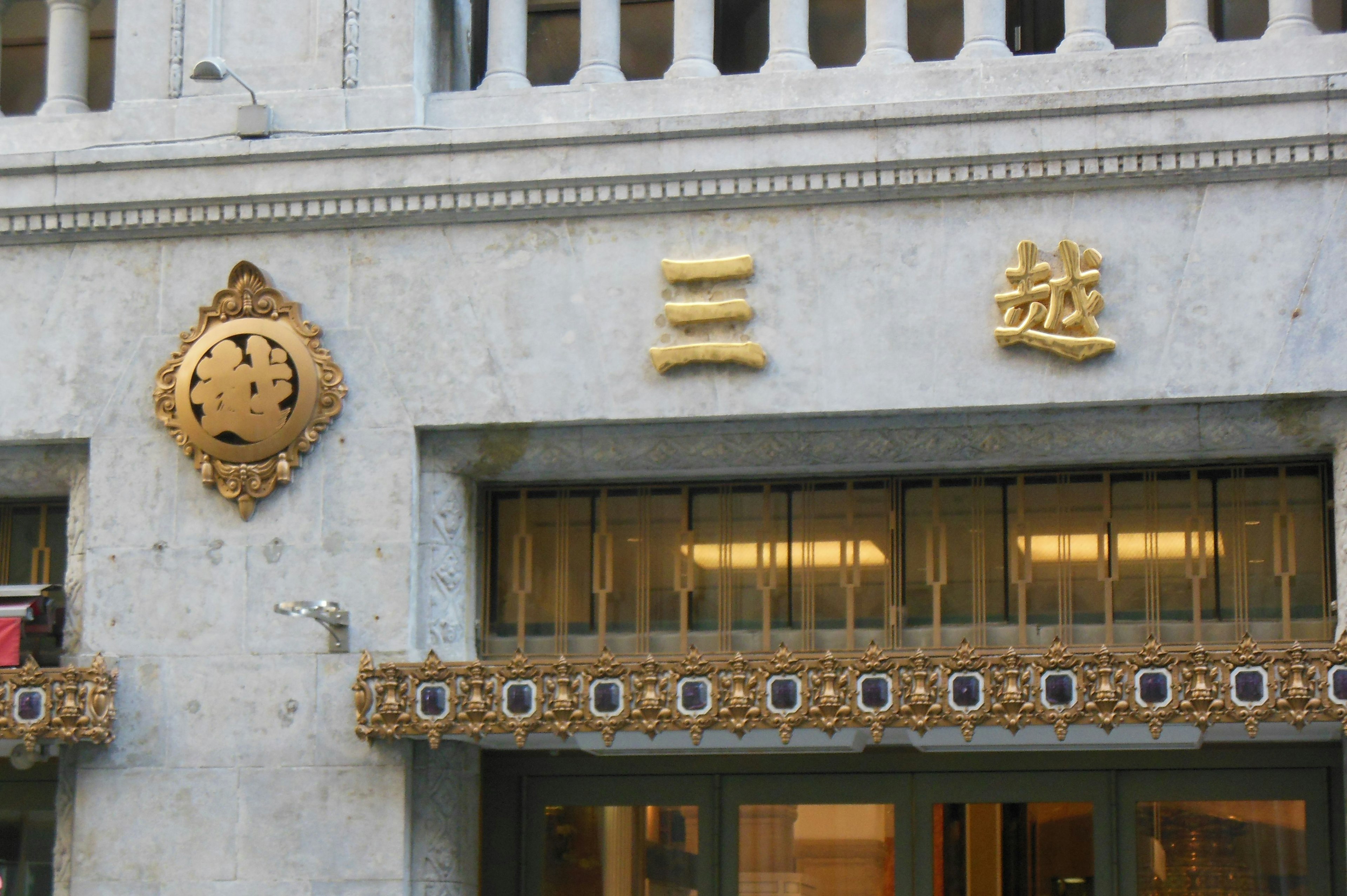 Exterior de un edificio con letras doradas y detalles decorativos