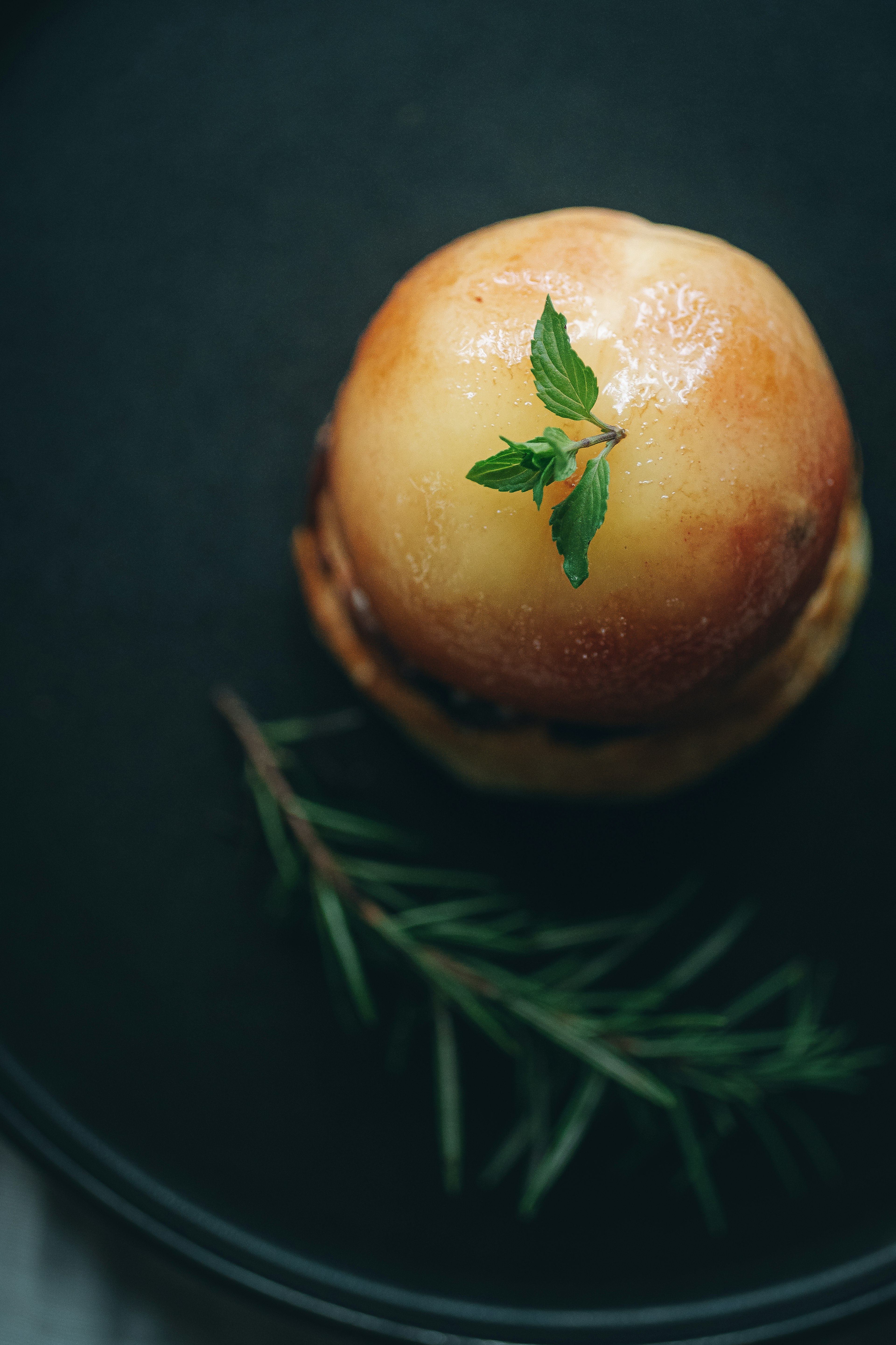 Pain moelleux avec une branche de menthe sur une assiette noire