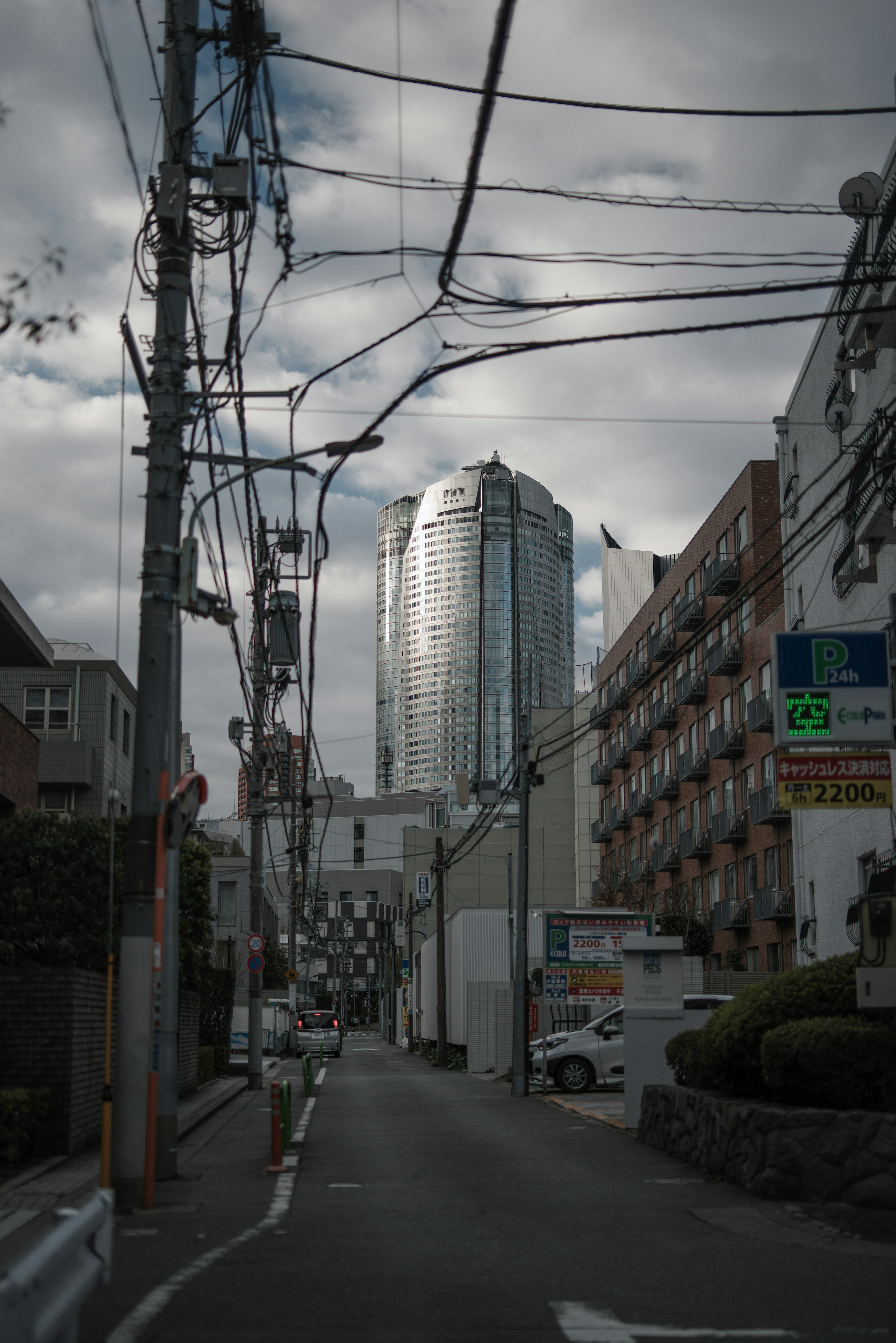 Rue étroite dans la ville avec un grand bâtiment et des lignes électriques