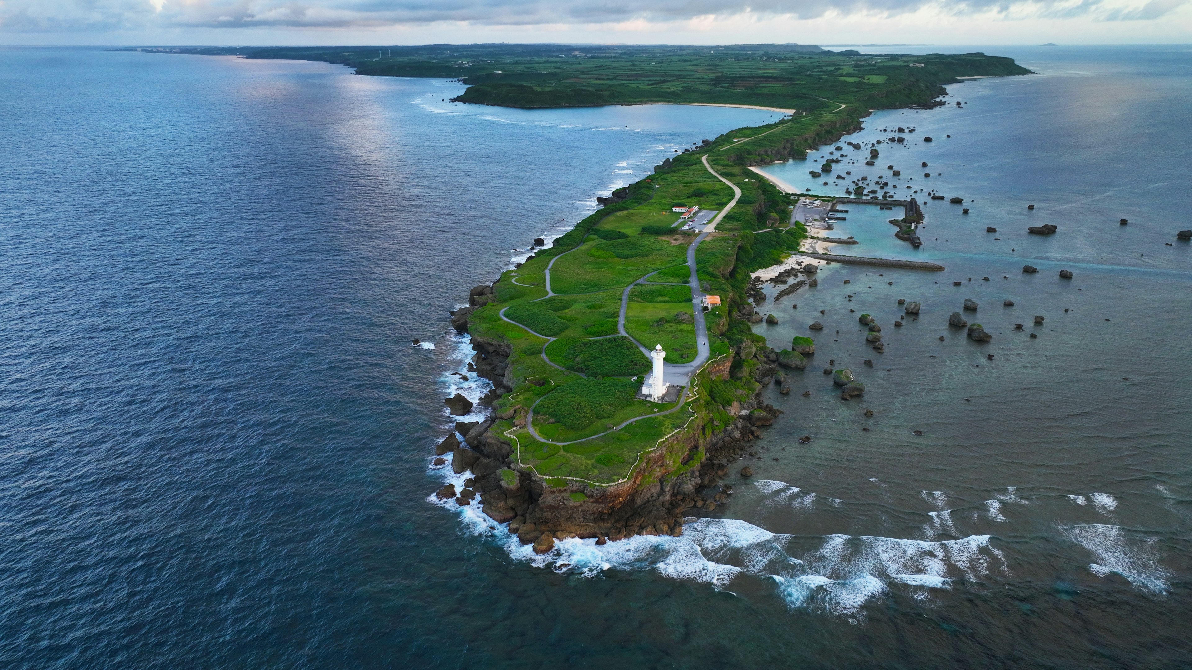 ภาพถ่ายทางอากาศของเกาะสีเขียวที่ล้อมรอบด้วยมหาสมุทรสีน้ำเงิน