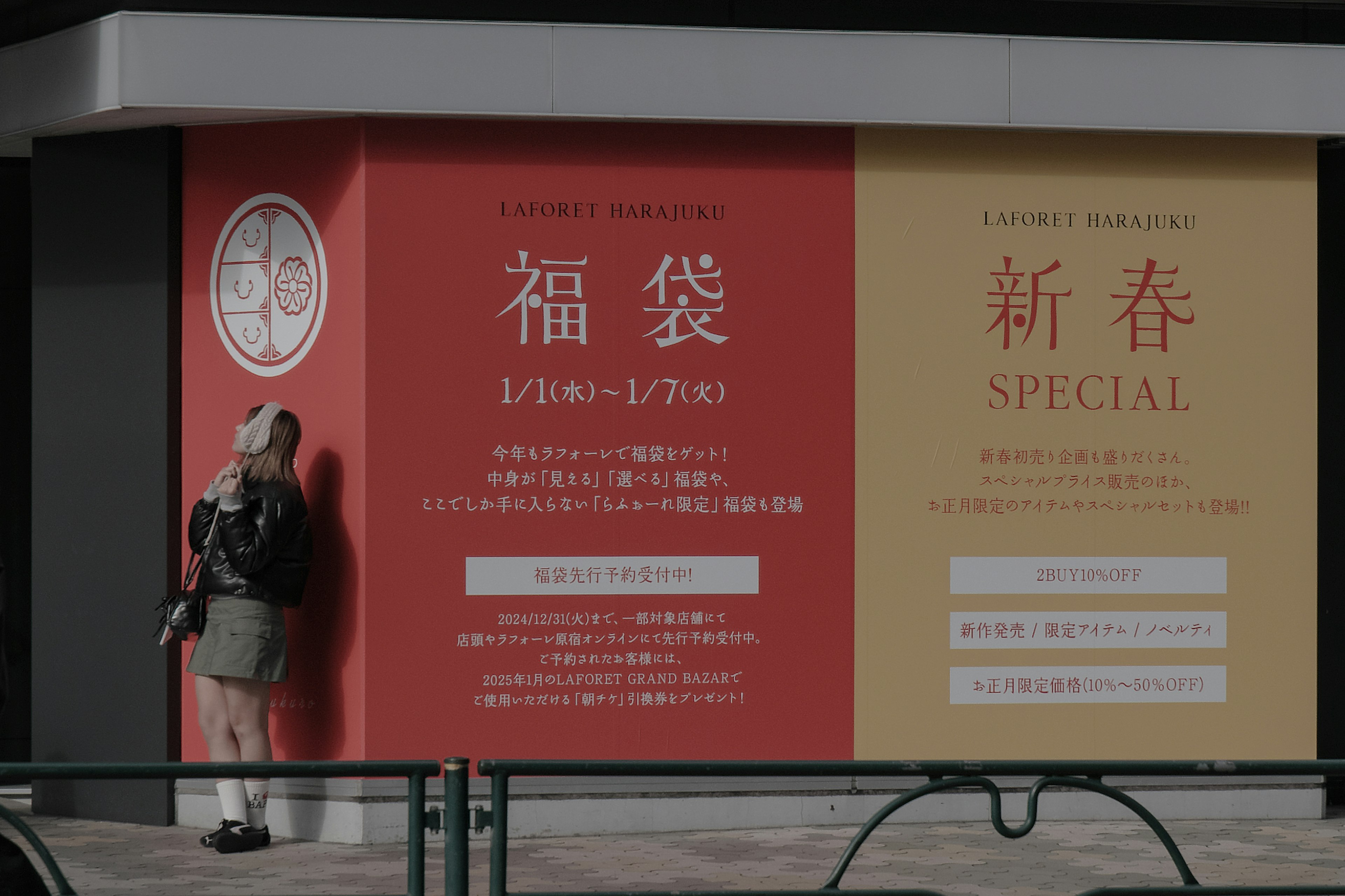 Person standing in front of a red and yellow banner featuring Fukubukuro promotion