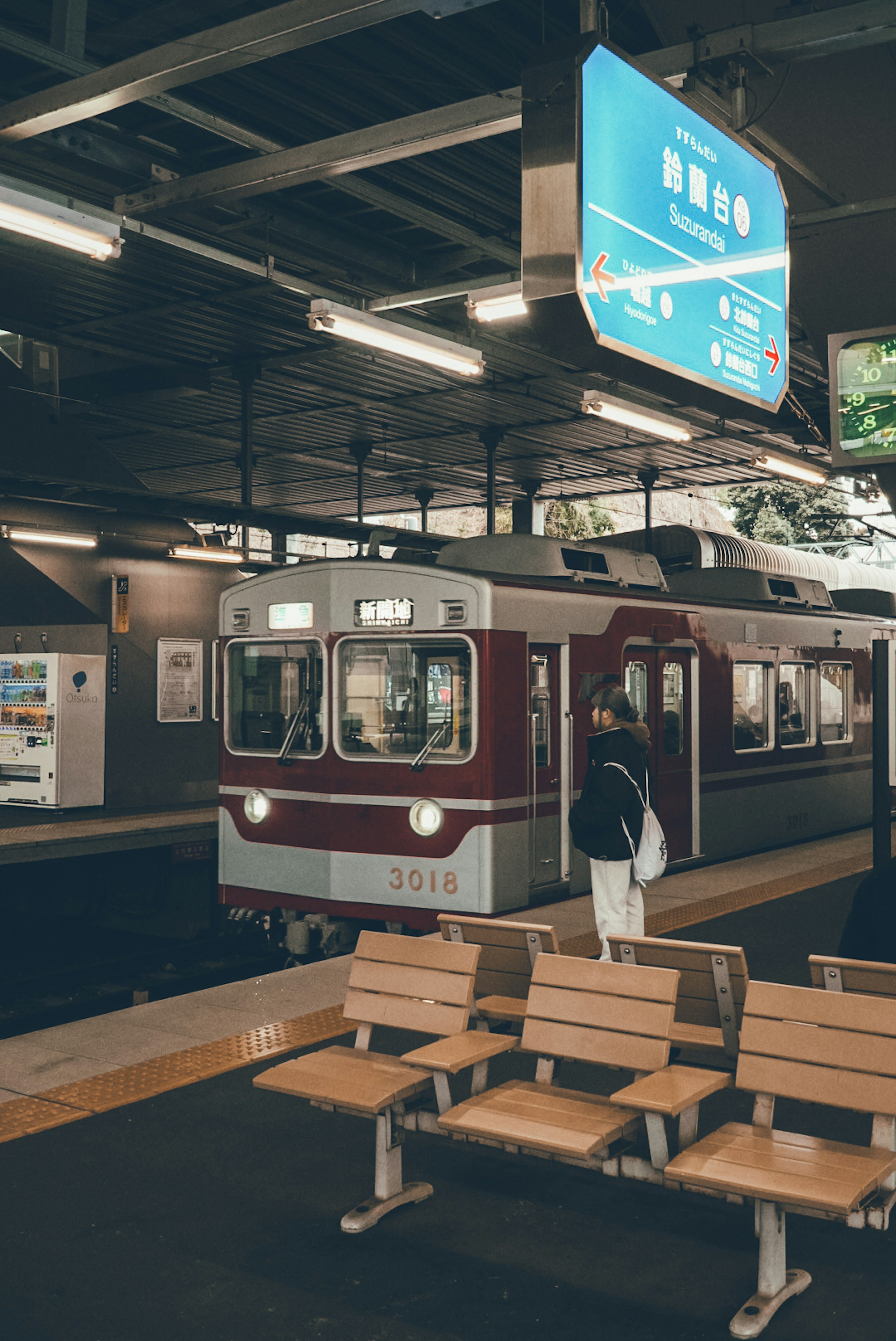 A train at a station with benches and signage