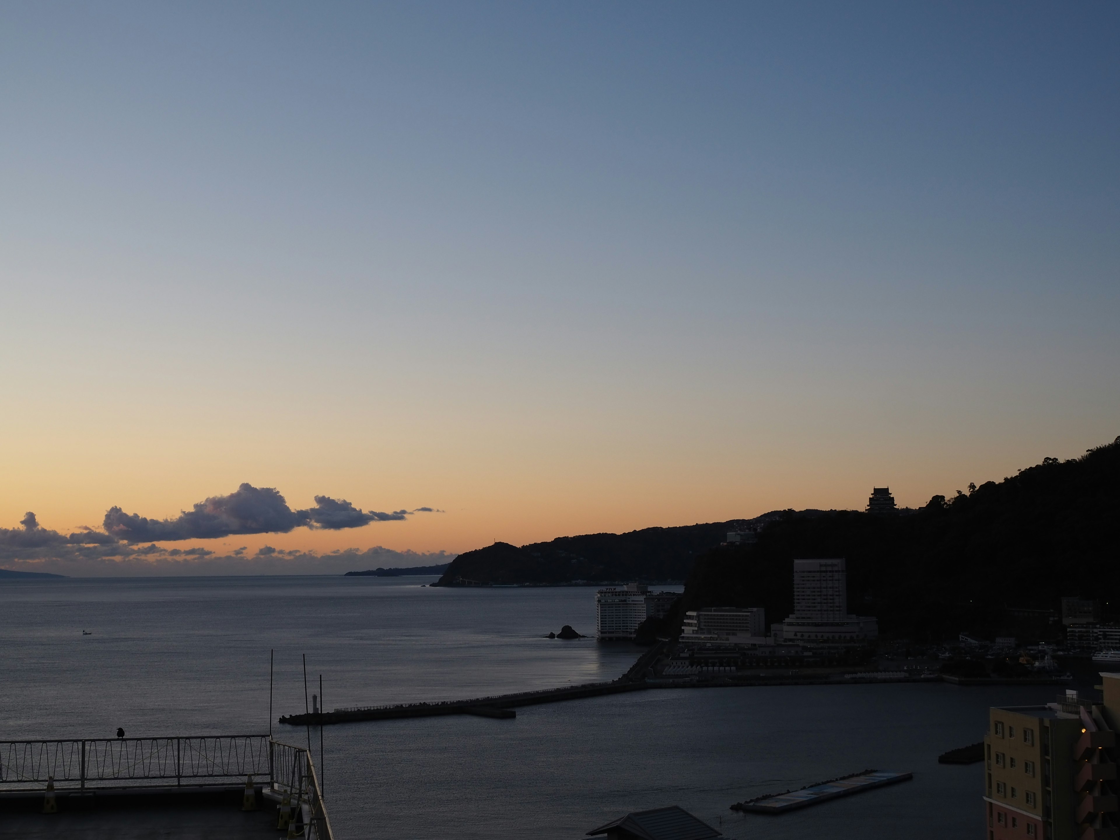 海と夕焼けの美しい風景 港と山々のシルエット